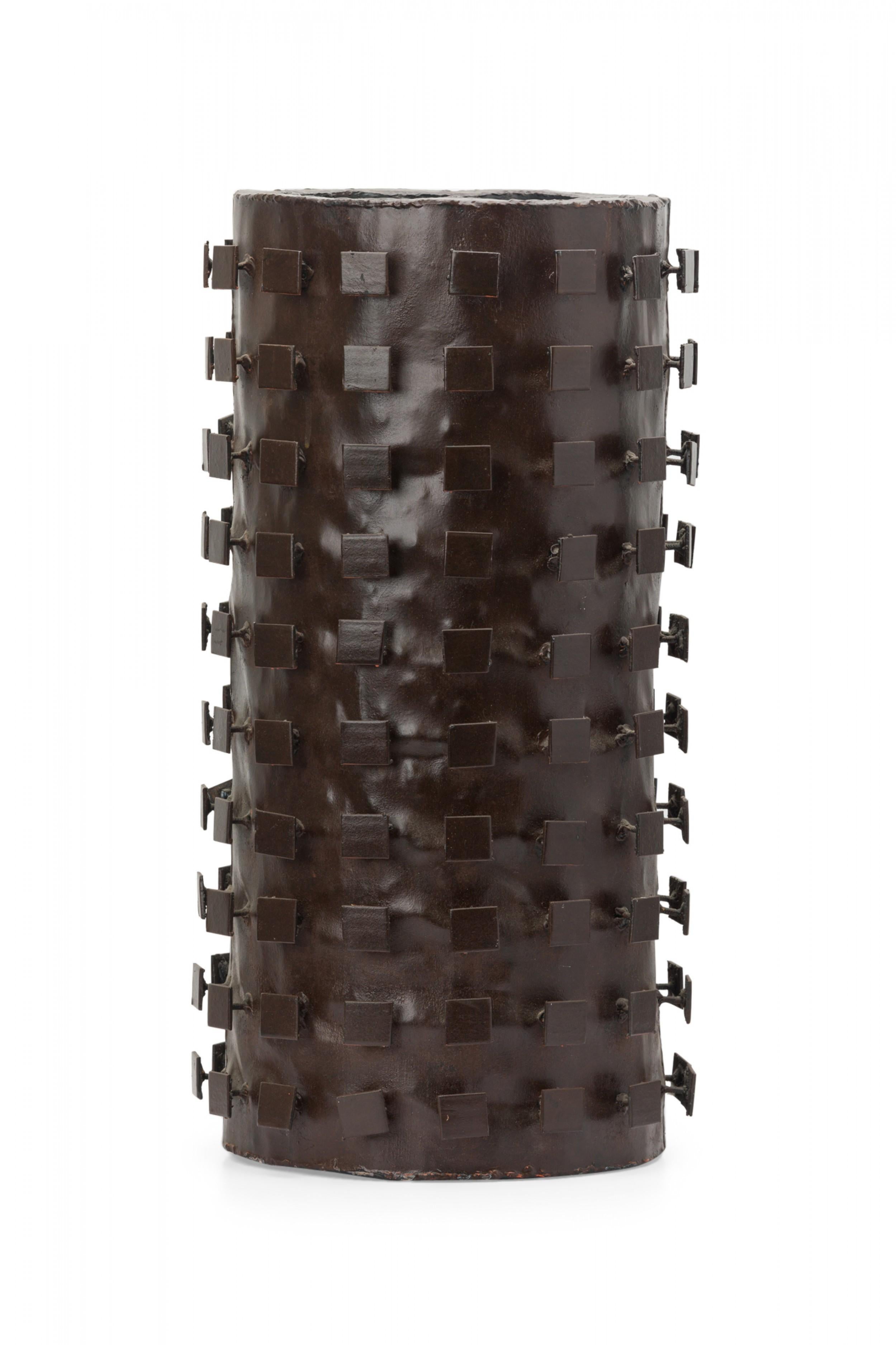 American mid-century Brutalist-style patinated steel cylindrical umbrella stand with a design of spines ending in steel squares around the exterior.