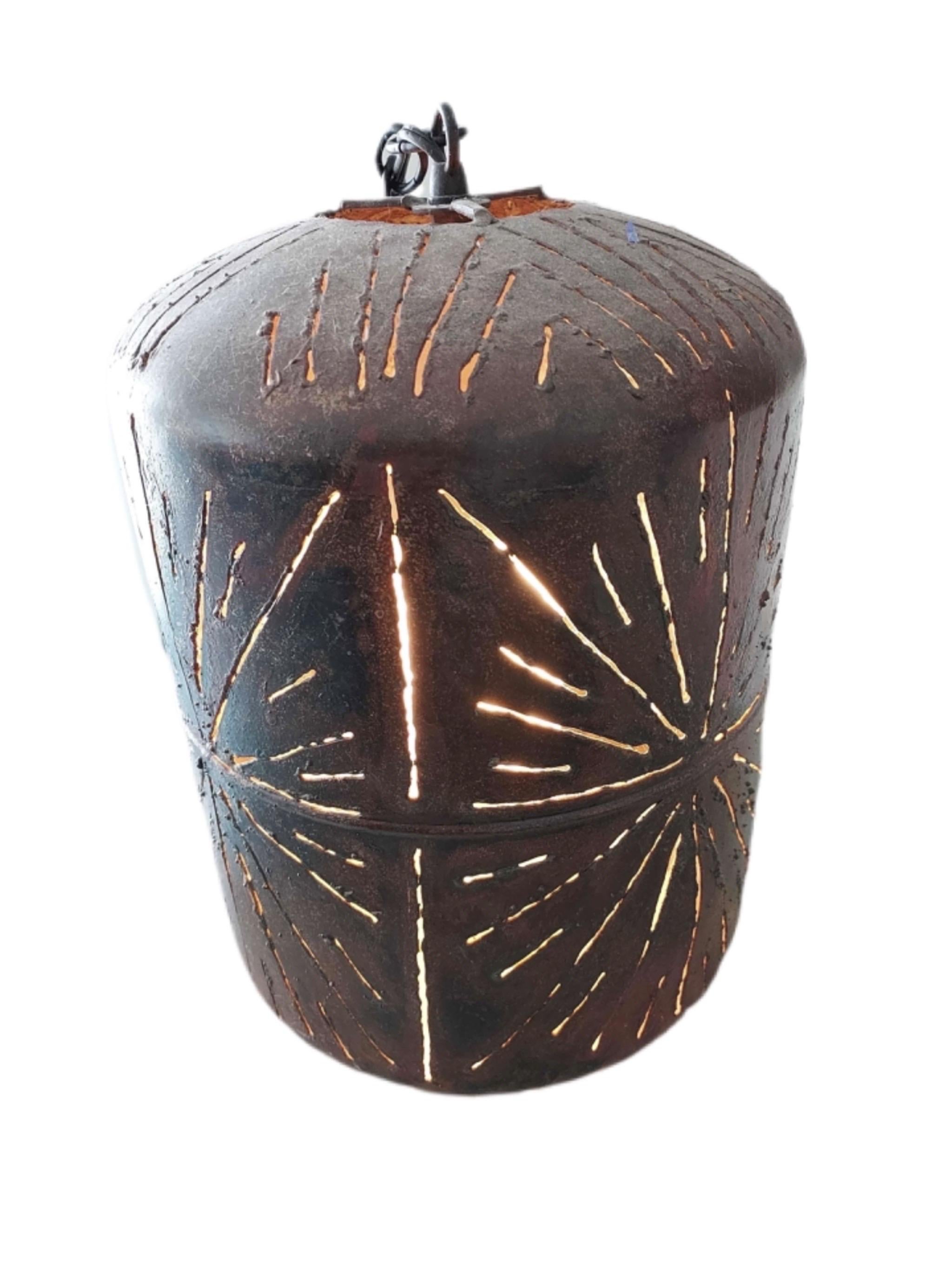 Qui abbiamo una grande lampada a sospensione in metallo forato. Quando si accende, il disegno è quello di un'esplosione di stelle. Sembra essere stato forgiato a mano. Un pezzo davvero unico da aggiungere alla tua casa unica. Attualmente è cablato