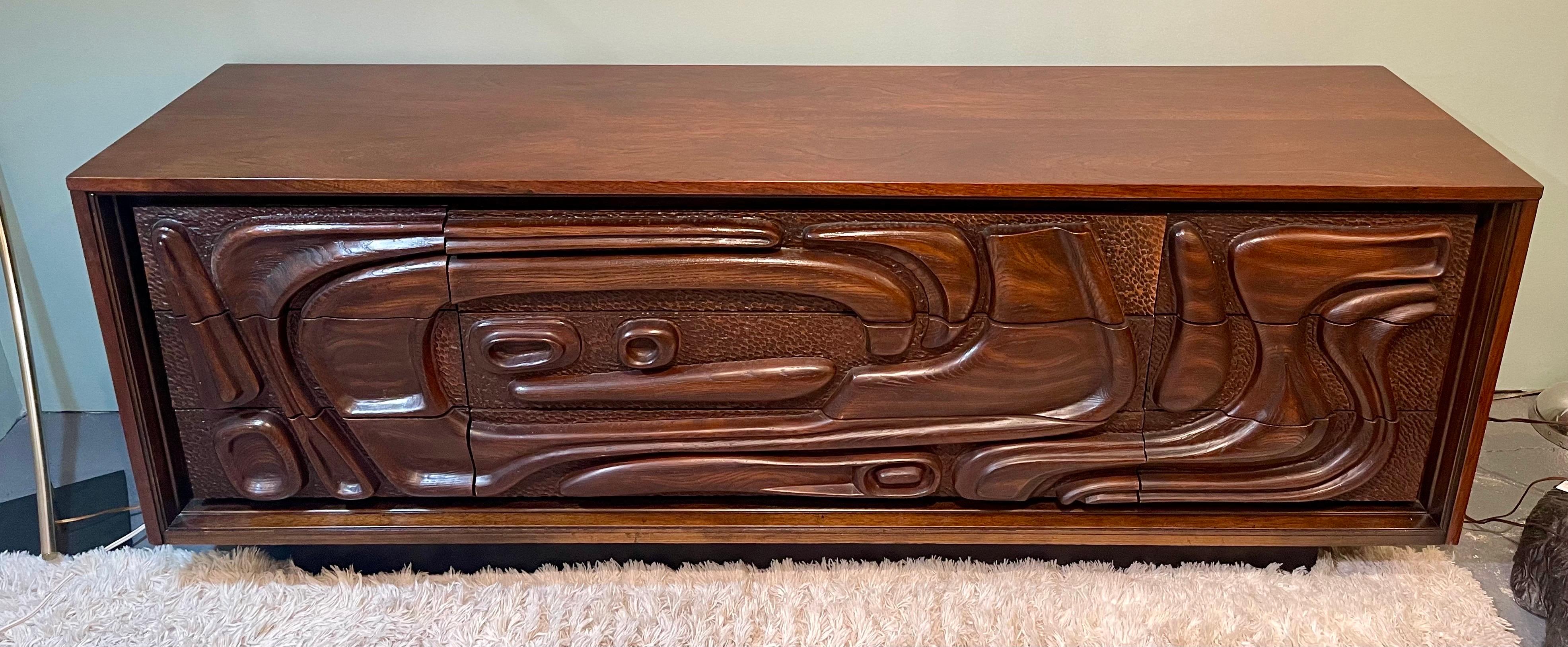 Crafted with meticulous attention to detail, this Pulaski Oceanic Brutalist Gentleman's long lowboy dresser features a commanding presence with its unique carved front and spacious drawers. The Oceanic-inspired carved facade creates a mesmerizing