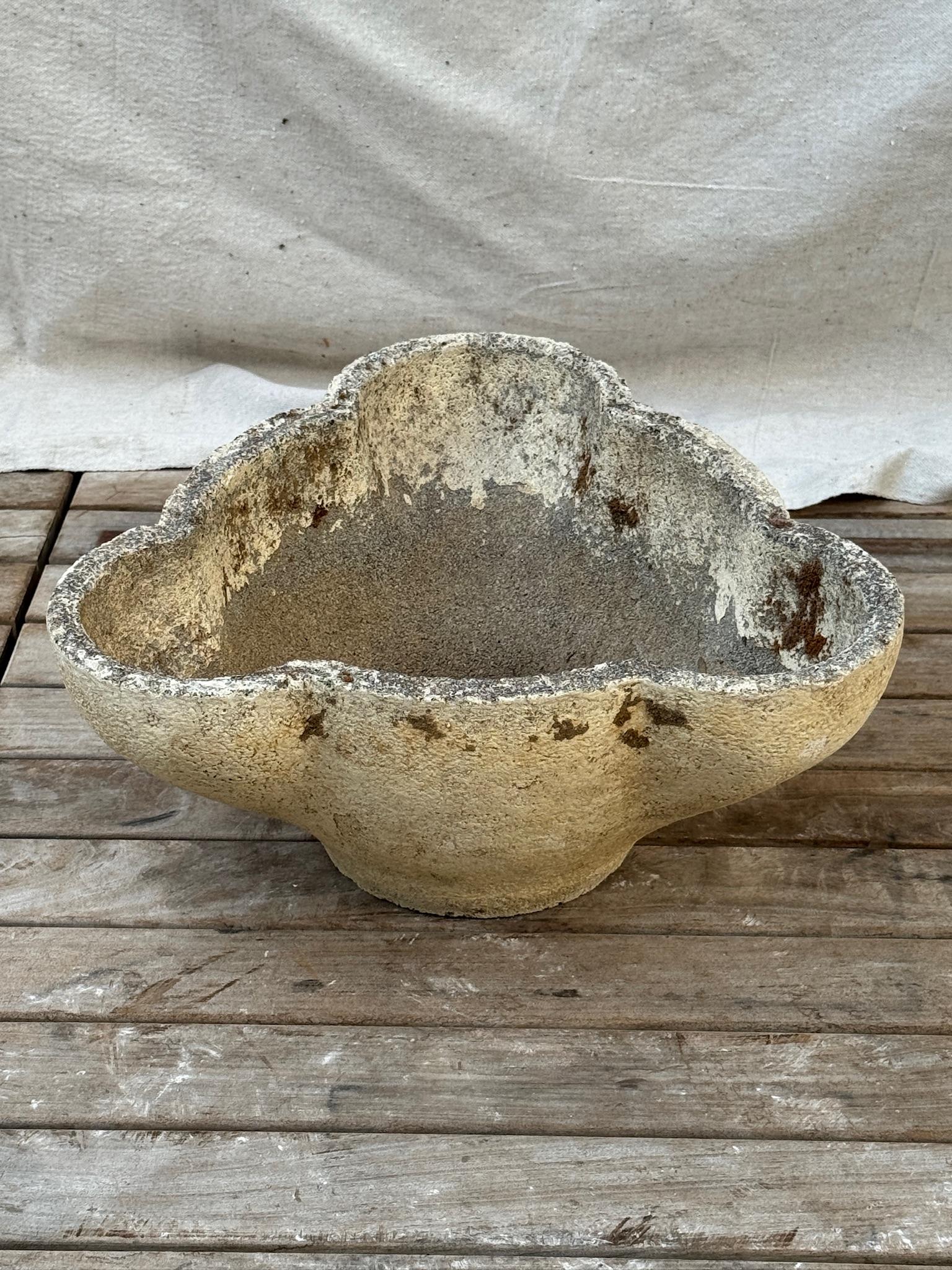 This striking mid-century Brutalist planter features a rare sculptural clover or cloud-shaped silhouette, hand-poured in concrete and beautifully weathered by time. The organic, asymmetrical rim and heavily textured surface exude a raw, elemental