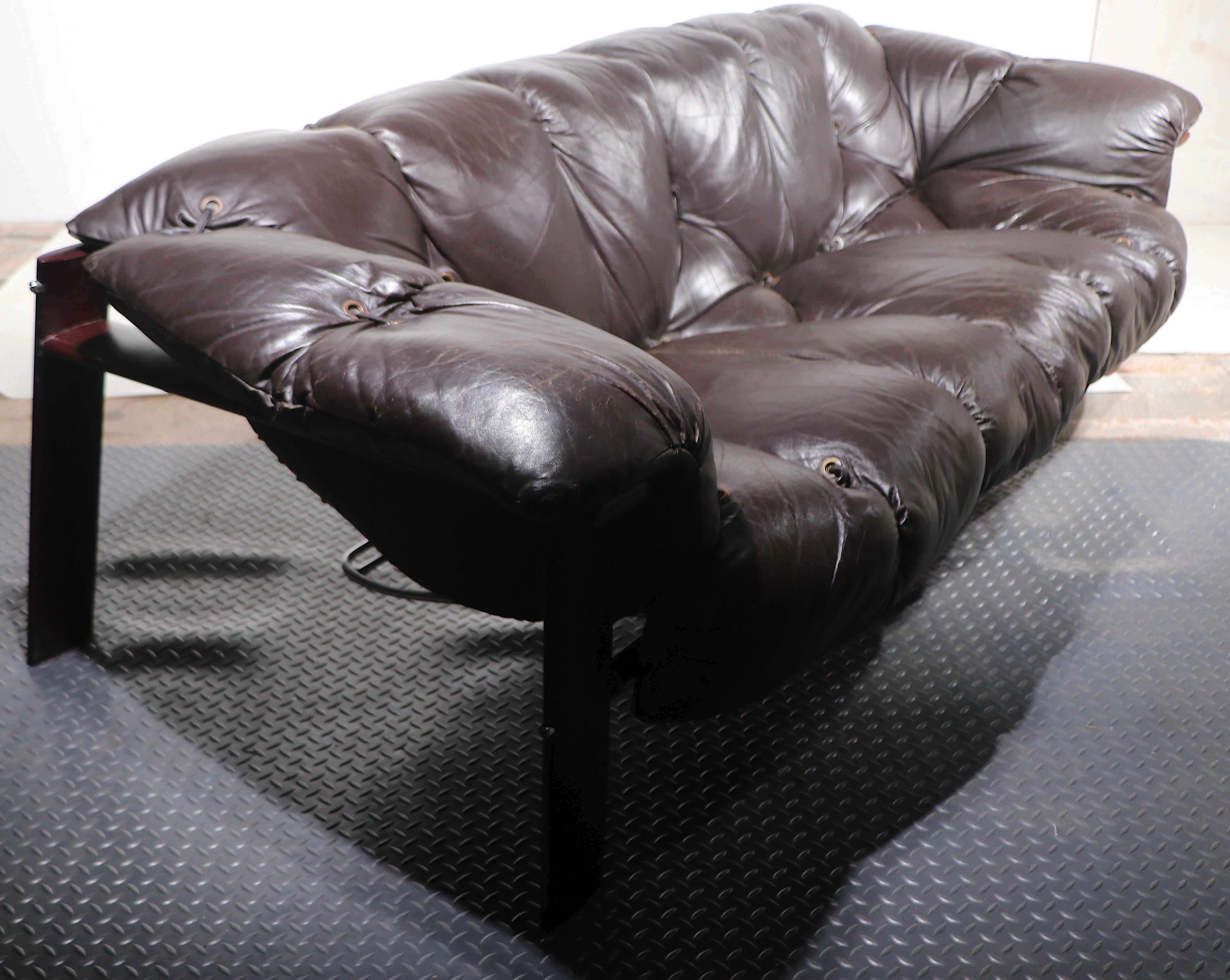 Rare canapé Brutalist Mid Century, designé par Percival Lafer, fabriqué au Brésil, circa 1970's. Le canapé est constitué d'un cadre en bois dur rare et d'une assise et d'un dossier continus en cuir marron, originaux et extrêmement confortables. Le