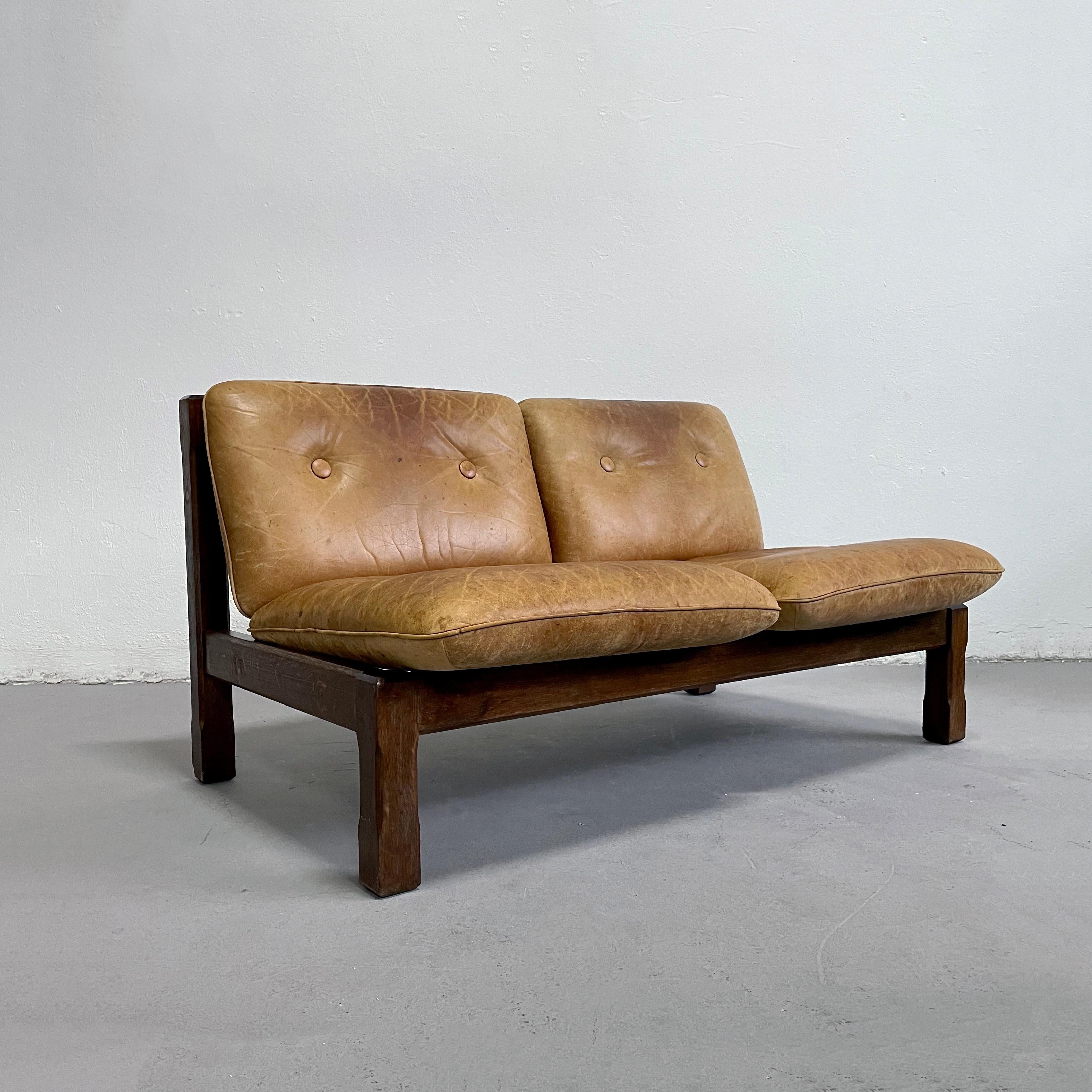 Vintage brutalist 2-seater sofa featuring solid oak frame and leather cushions

The leather is worn and has a lot of nice patina. It was professionally cleaned and the item is in good functional condition as intended.