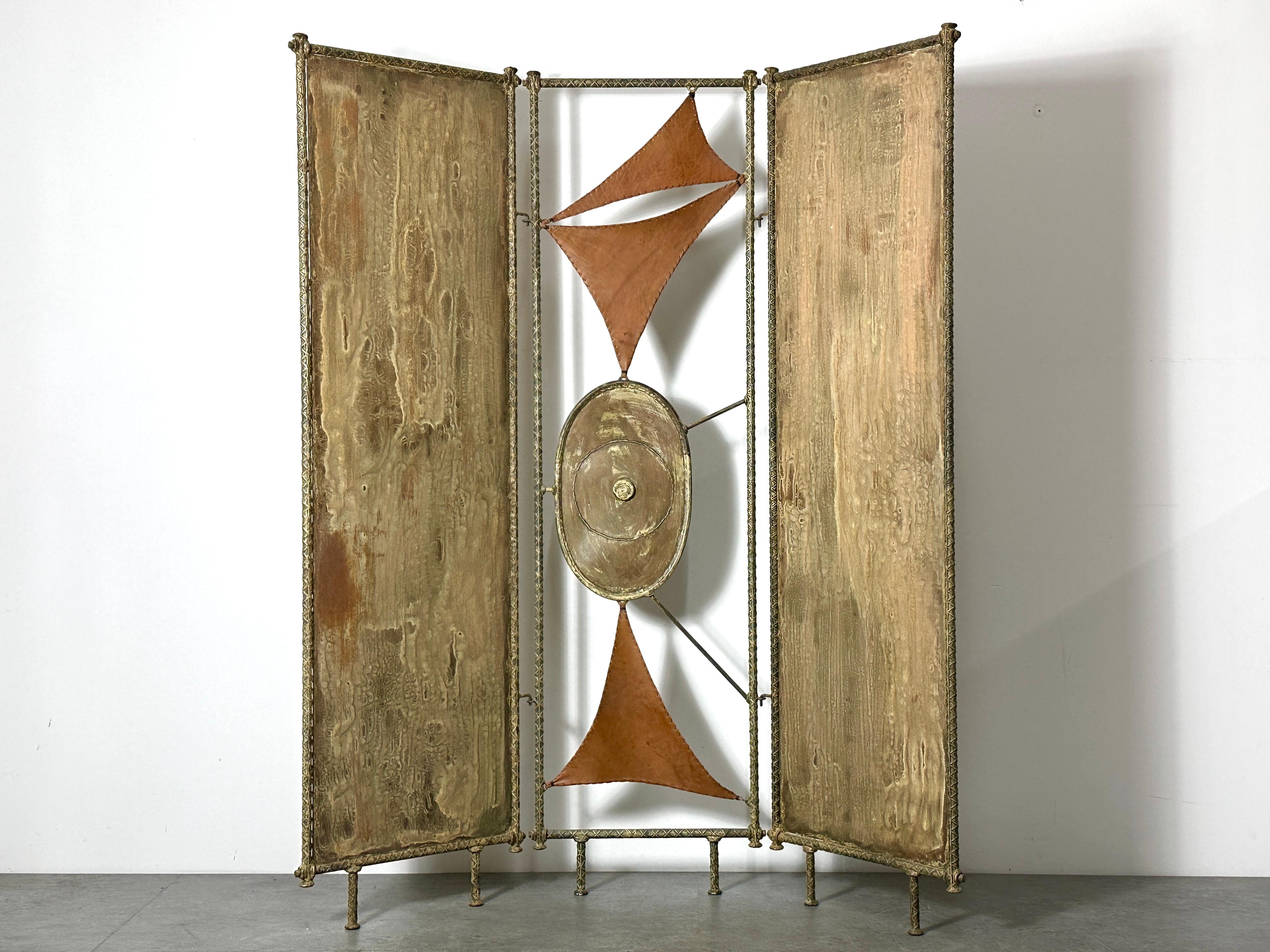 Exceptional one of a kind artist made room divider circa 1970s
Patinated steel three panel hinged design with modernist hand stitched leather detail and sculptural welded center piece
Presumably made by a Detroit area or Cranbrook artist

