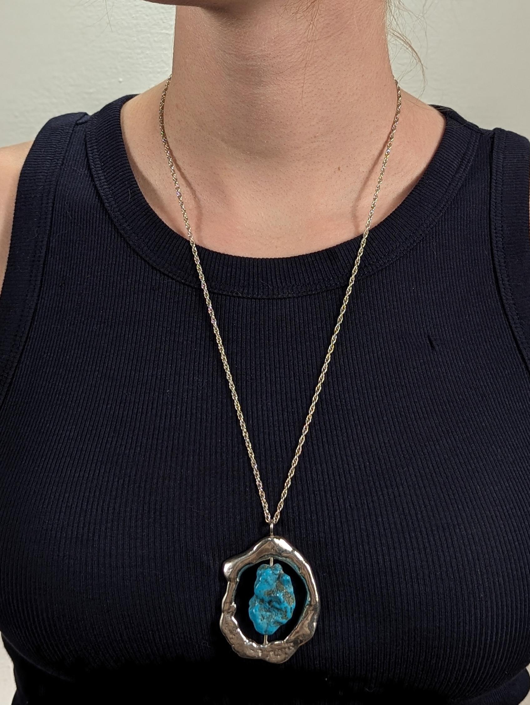 Una bella collana Brutalista del Mid-Century.

Si tratta di un pesante ciondolo in argento sterling fuso con una grande pepita di turchese lucidata incastonata al centro.

E viene offerto con una collana a catena in argento sterling.

Un ciondolo