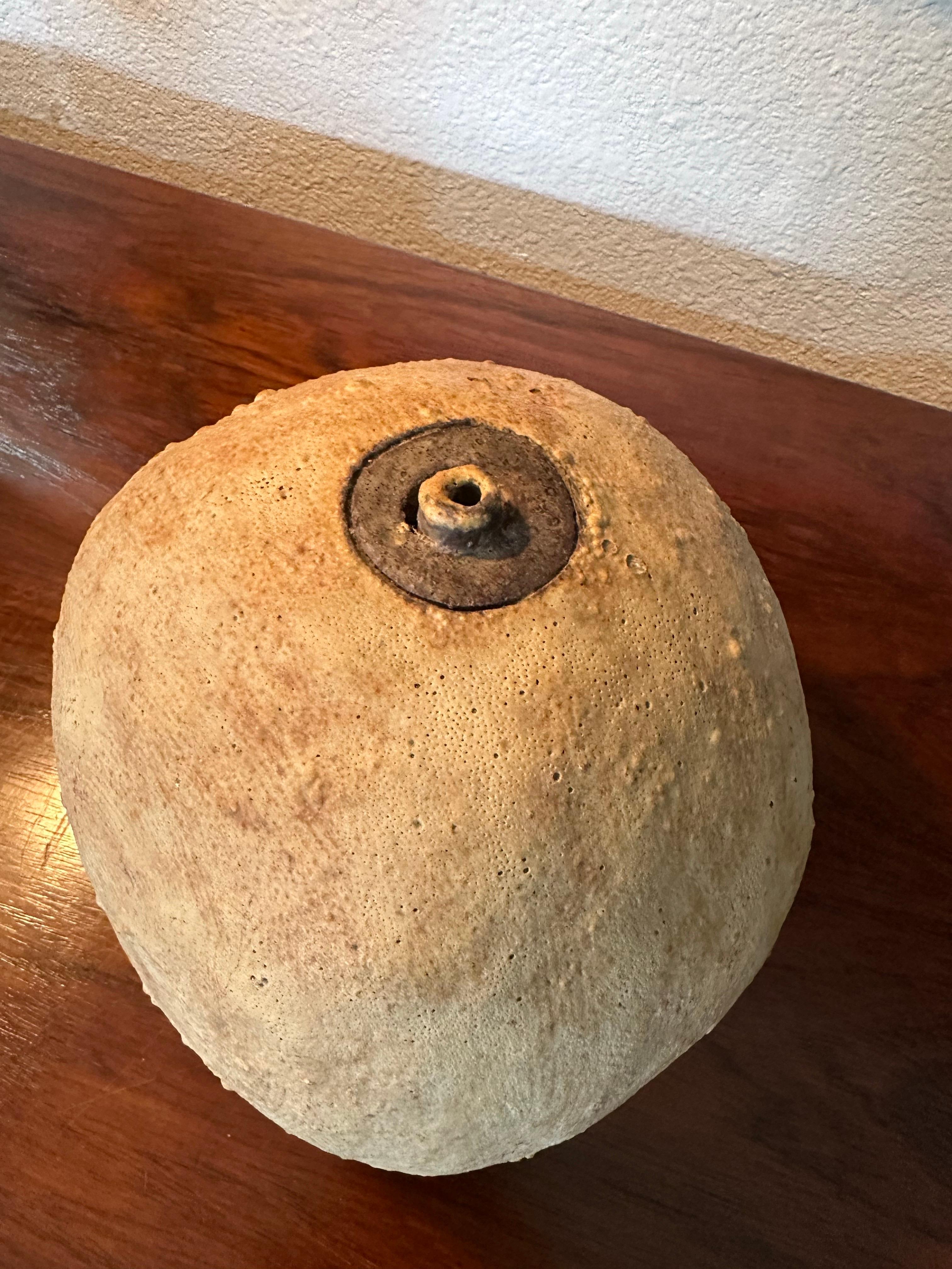 Vintage Mid Century earthy ball vase sculpture. Great texture and dimension in the matte tan glaze and slight lava texture with deep brown glazed rim to the small mouth opening on top. Vase is signed on bottom S. Croxall. Good vintage condition, no