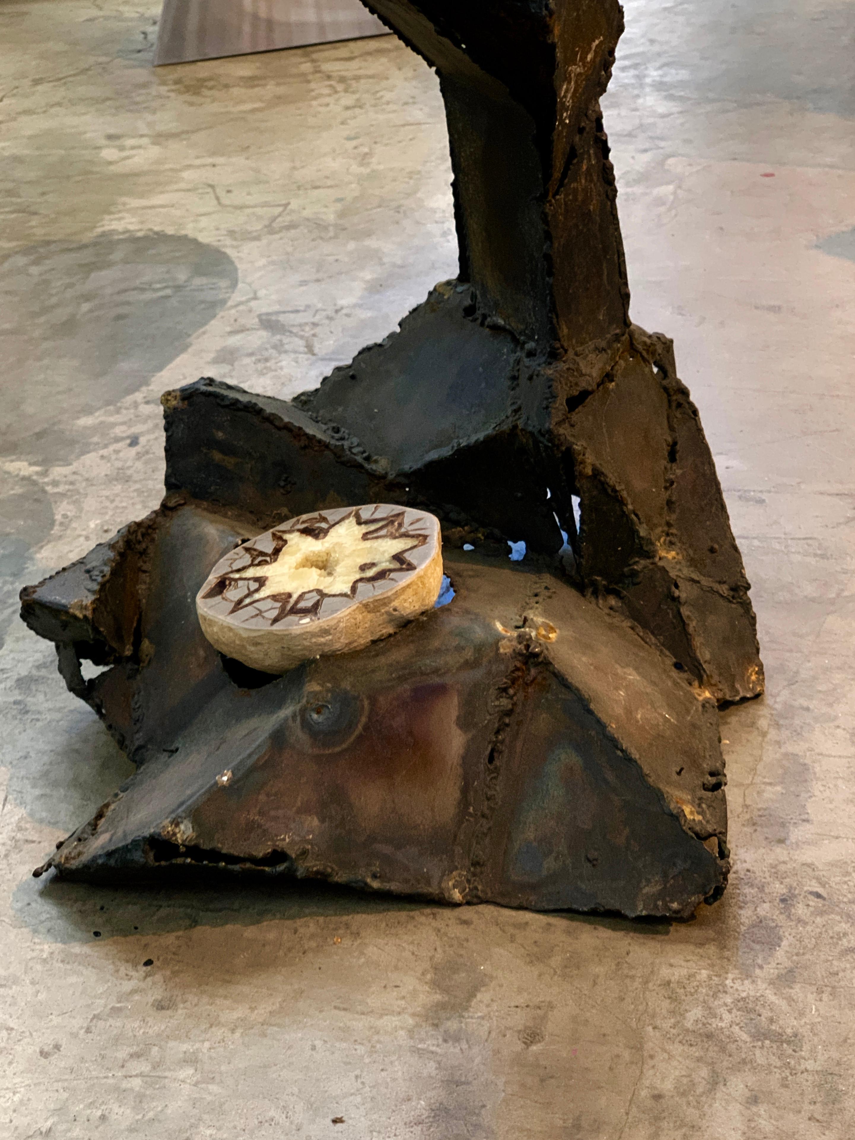 A fabulous midcentury Brutalist welded iron table with a Lucite top and a Septarian geode inset. This table was from the estate of Daniel Gluck. Unsure if he created it or acquired it. Not signed that we can find. Great form and presence. The iron