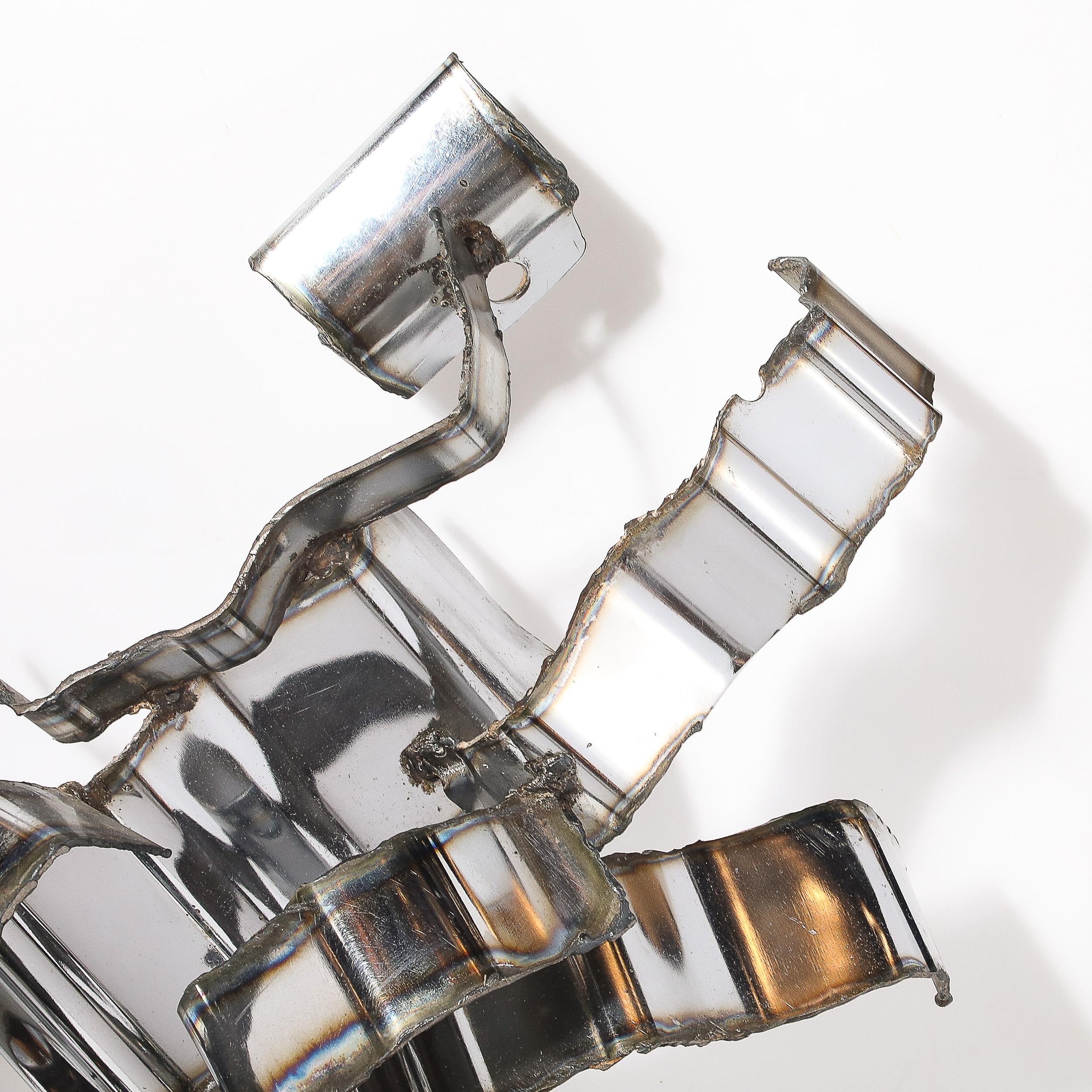 Signed by the renowned American artist Silas Seandel, this mid-century Brutalist wall sculpture from 1976 is a masterful fusion of industrial design and artistic craftsmanship. Crafted from repurposed industrial materials, its layered composition