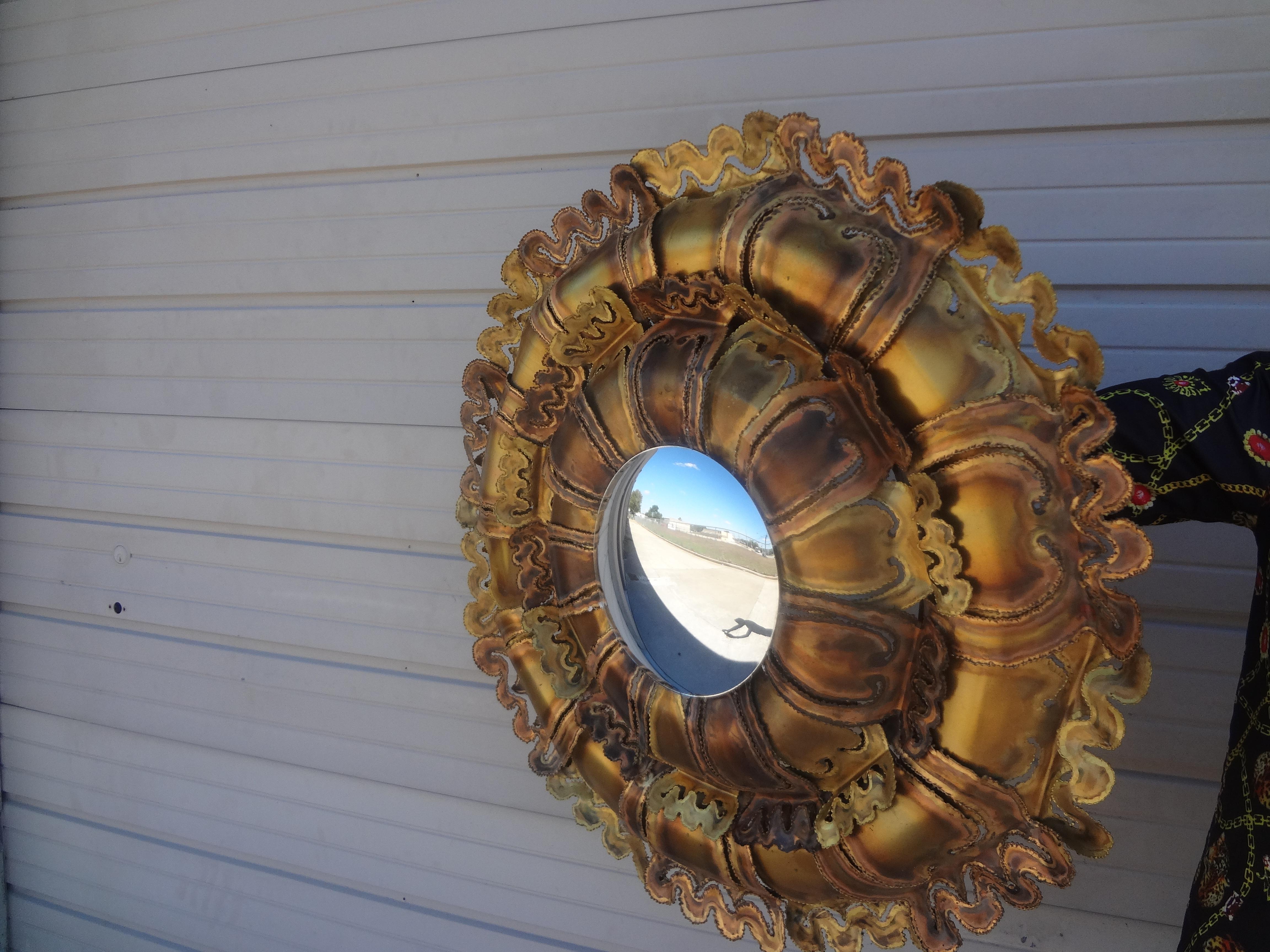 Midcentury Brutalist torch cut mixed metal convex mirror. This stunning Brutalist convex mirror or sunburst mirror was executed in mixed metals in a very interesting design.
Our mid century torch cut round metal mirror would work well in a variety