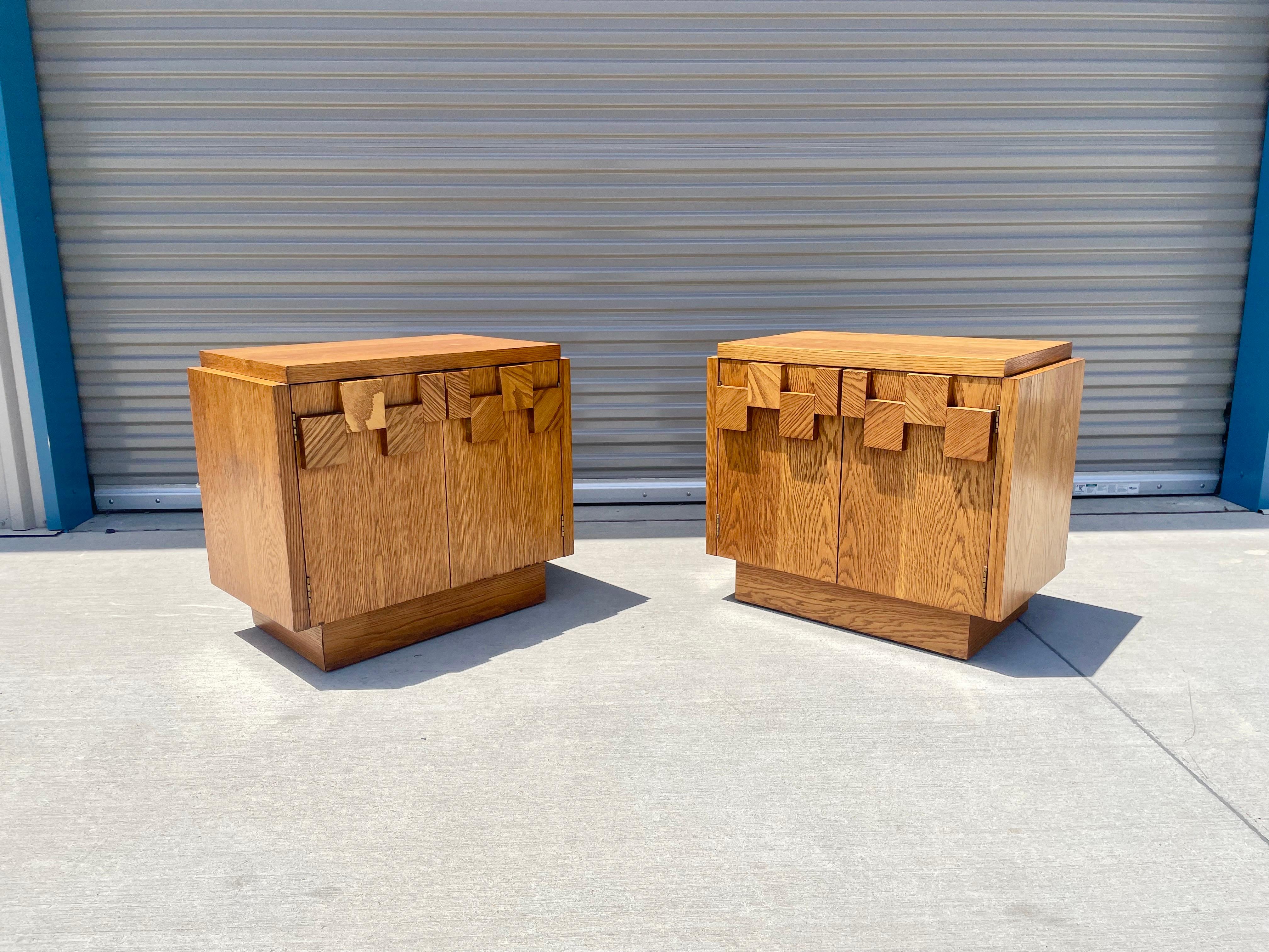 Mid-century brutalist walnut nightstands by lane. These stunning nightstands have a unique style it making them one of a kind. They feature a stained light walnut finish to it with two pull outdoors, and each nightstand has one shelve.