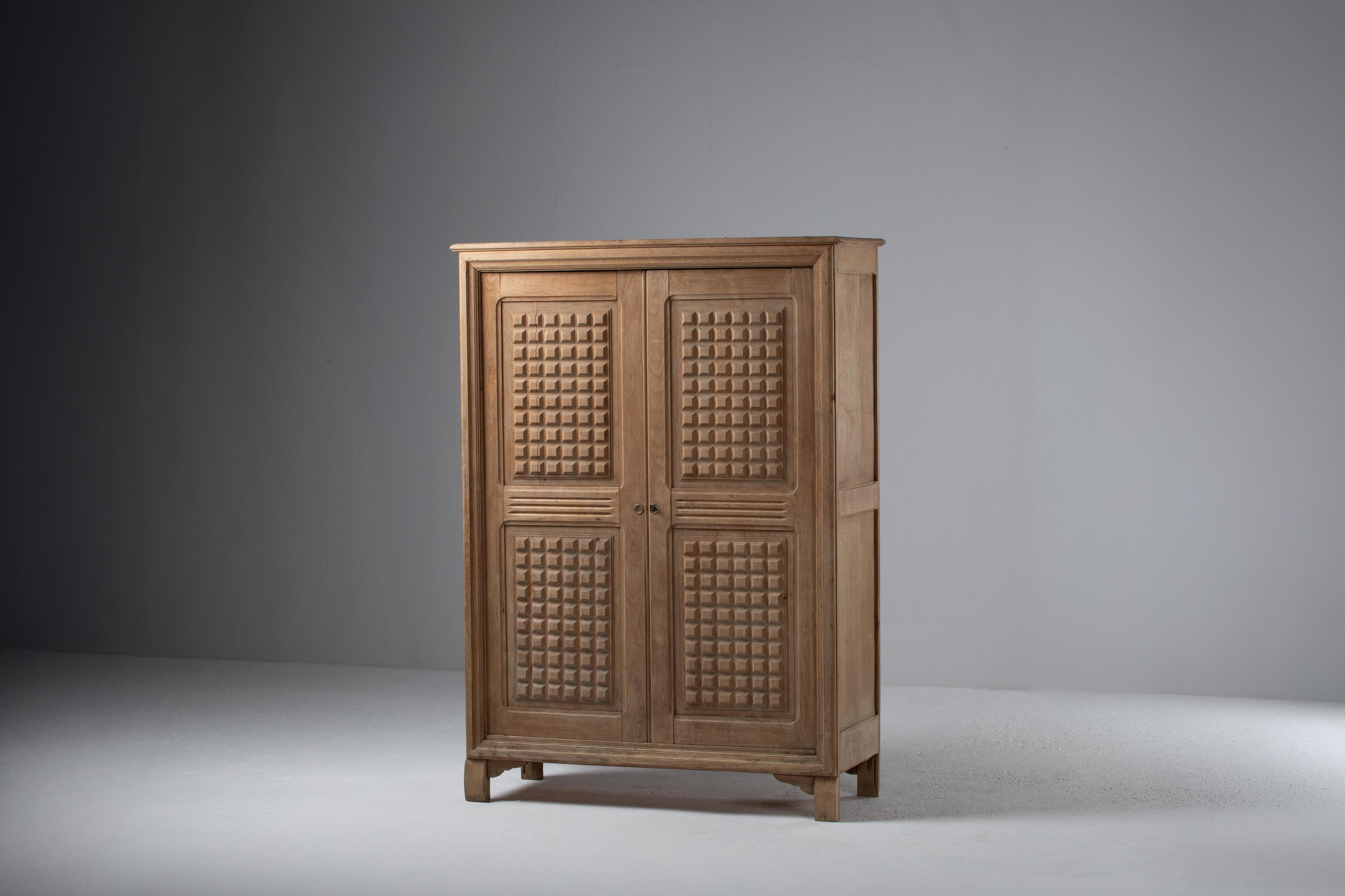 Introducing a captivating Solid Oak Wardrobe from the 1950s, this exceptional French piece showcases distinct square patterns on its doors, drawing inspiration from the bold aesthetics of brutalism. Crafted with meticulous attention to detail, the