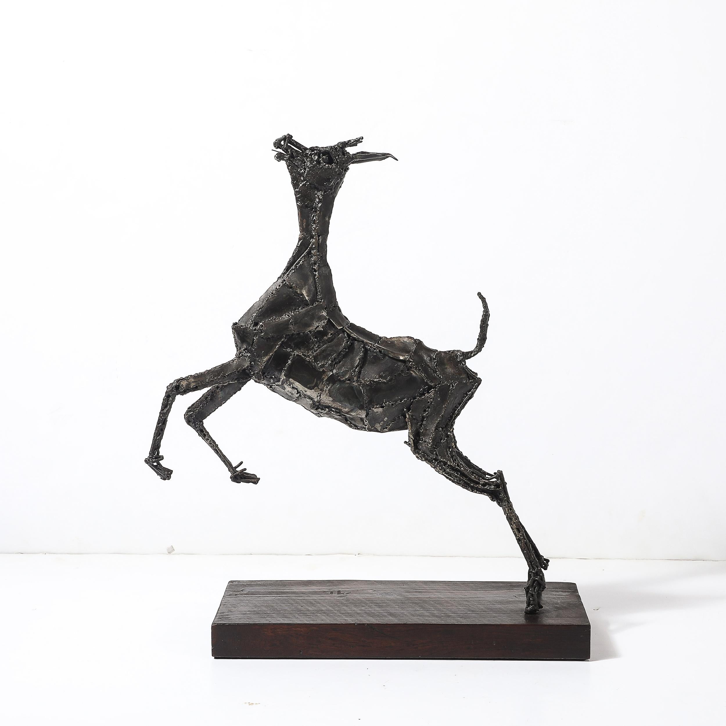 This striking Mid-Century Brutalist sculpture of a leaping goat is a masterful example of welded bronze artistry. The dynamic composition captures the energy and grace of the goat mid-leap, with sharp, angular lines and textured details that are
