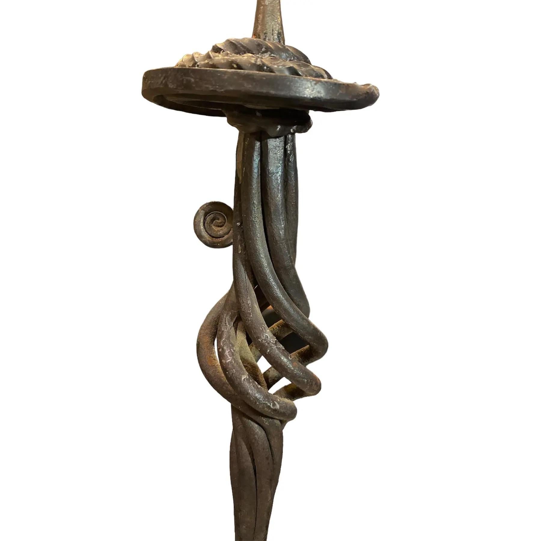 Boldly sculptural and unapologetically raw, this Mid-Century Brutalist floor candlestick stand is a striking example of artisan blacksmith craftsmanship. Forged from heavy wrought iron, its design features a twisted spiral stem that rises