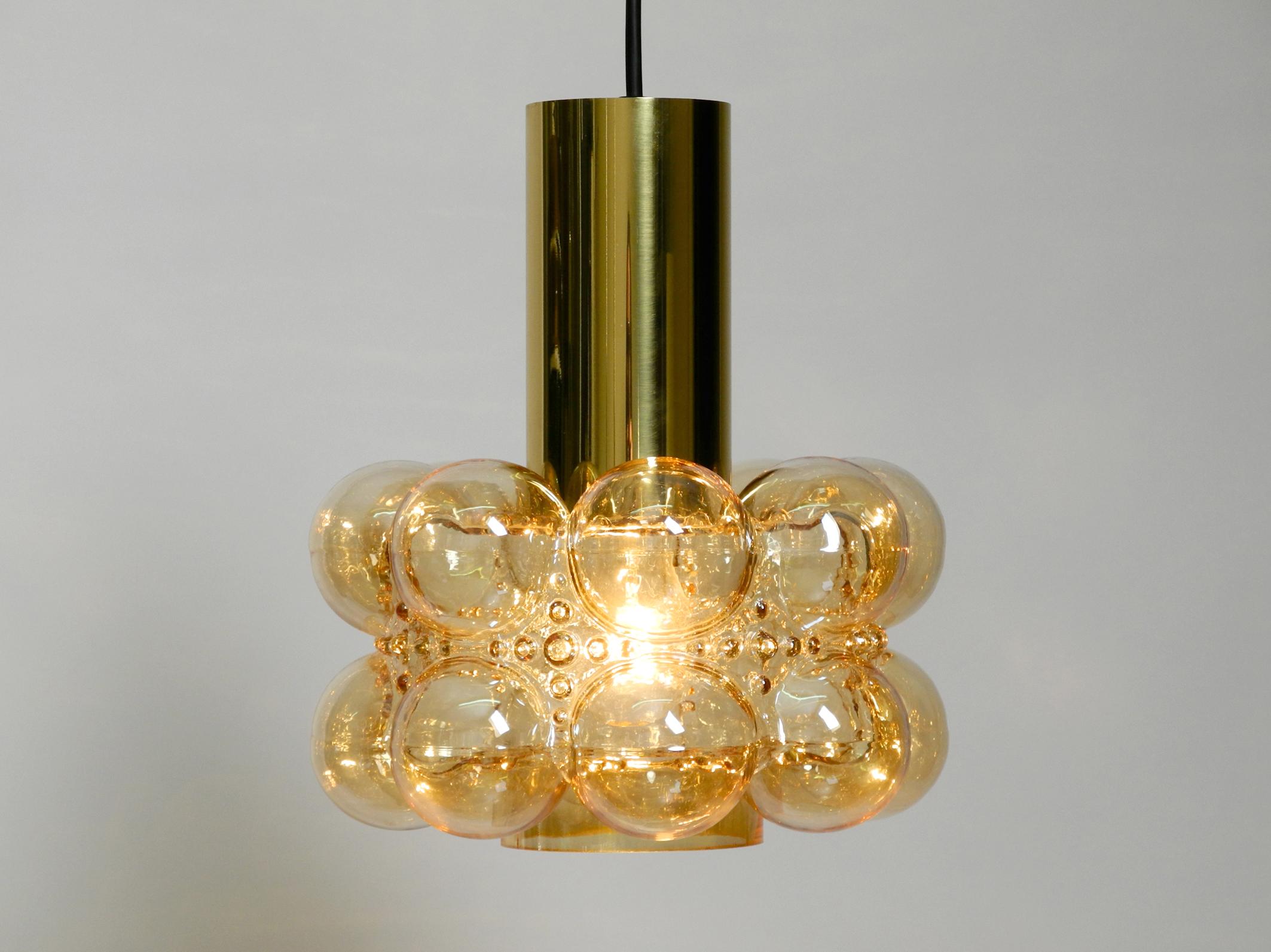 Beautiful large midcentury bubble glass pendant ceiling lamp by Helena Tynell for Limburg.
Creates a beautiful warm light for all rooms.
In almost new condition with no damages. The attachment above the glass shade is made of shiny brass.
Glass