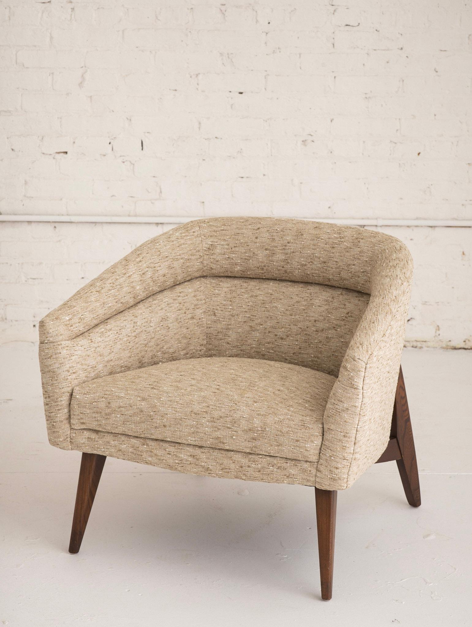 Classic mid century lines on this sleek bucket chair. Newly upholstered in a textured woven fabric. Solid wood frame.