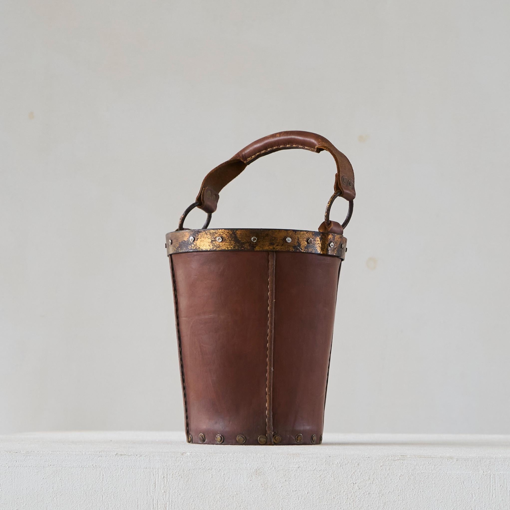 Mid Century Bucket or Basket in Leather and Metal.

Wonderful mid century bucket / waste paper basket / paper roll basket in patinated dark brown leather and gold painted and patinated metal. Just a great piece with a very nice 'casual' appearance.