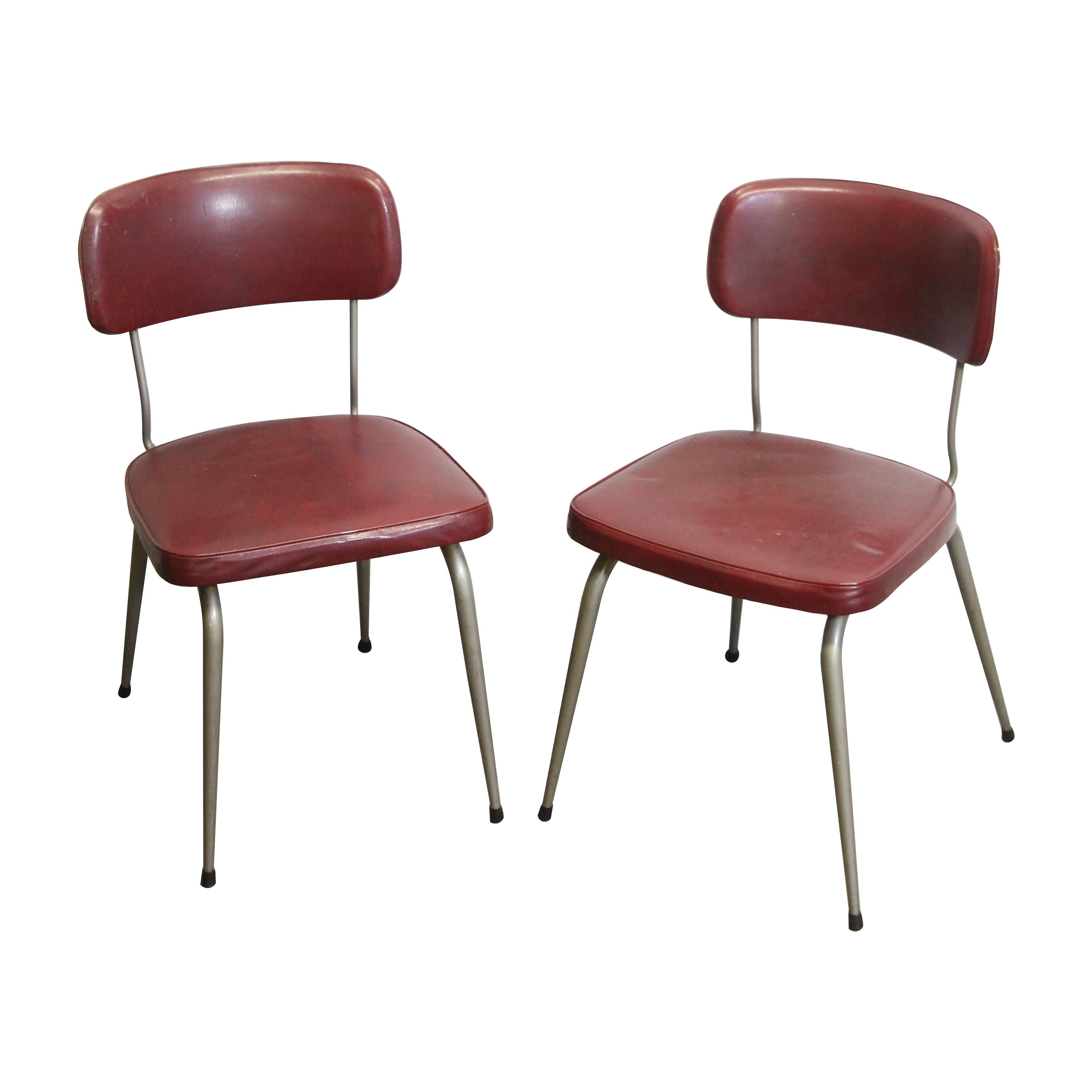 Pair of 1950's chairs from Belgium with burgundy colored vinyl seats and metal legs made by Strafor. The back is stamped Acior Trooz- (Belgique). Priced as a pair. Please note, this item is located in our Los Angeles location.