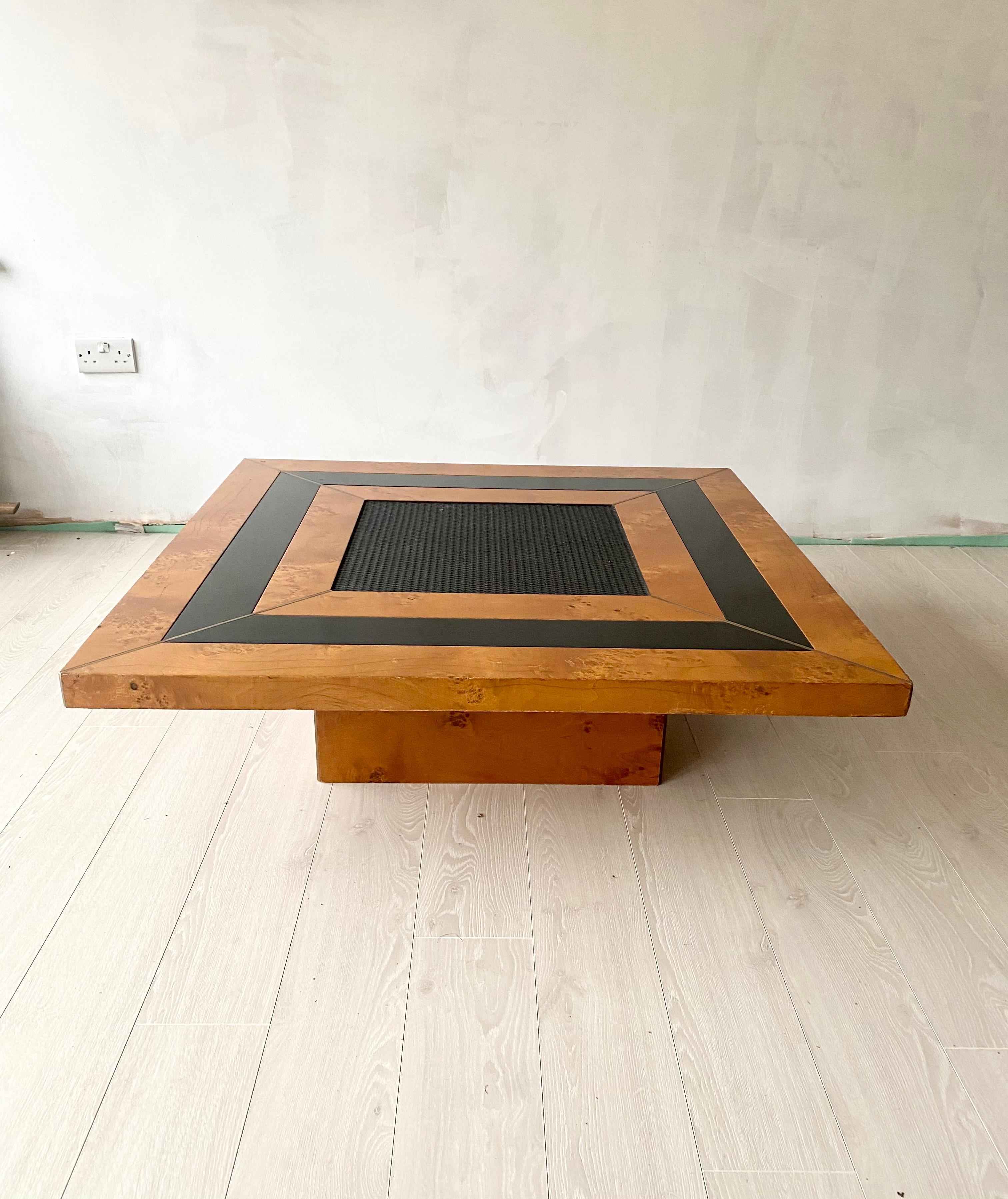 A beautiful vintage coffee table made of burl wood with a woven centre and brass inlay.
Sleek low design with a black lacquer strip wrapping all the way around the top between the burl. 
A brass trim runs from each corner to the centre. 
Quality