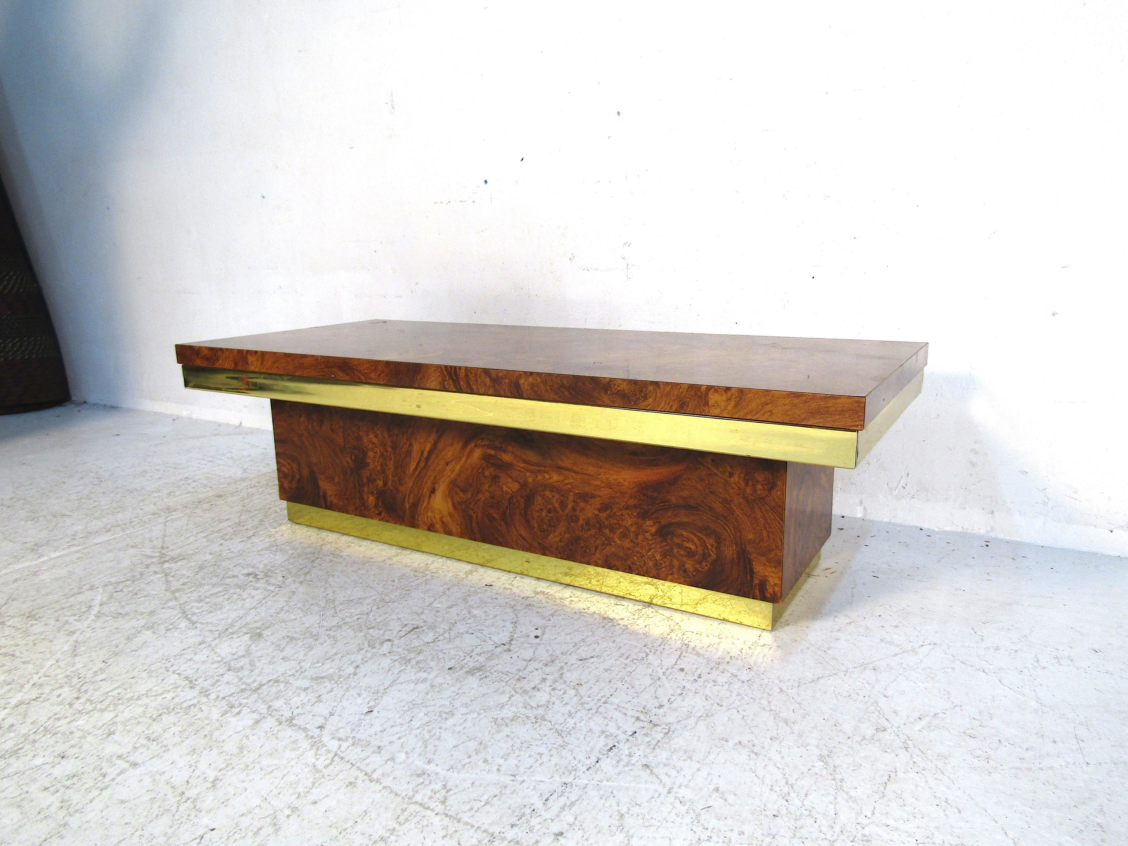 This beautiful midcentury coffee table features stunning burl wood panels and brass accents. This piece will fit perfectly in any contemporary or midcentury style space. Eye-catching this table will be sure to be a conversation piece for years to