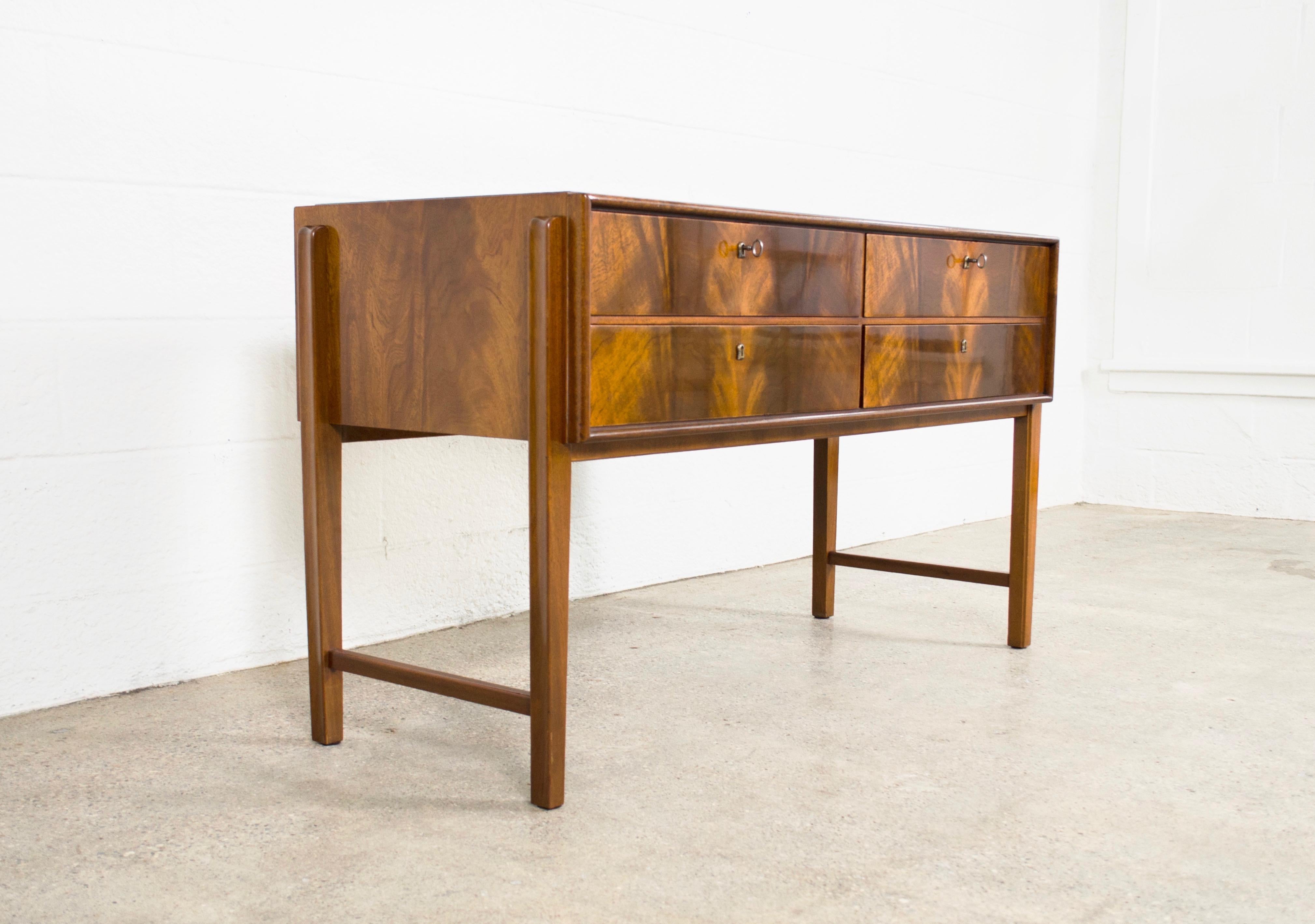 This exceptional vintage Mid-Century Modern sideboard buffet circa 1960 is impeccably crafted and features a lacquered burl wood surface with stunning grain pattern and a recessed glass tabletop. The four locking drawers have dovetailed construction