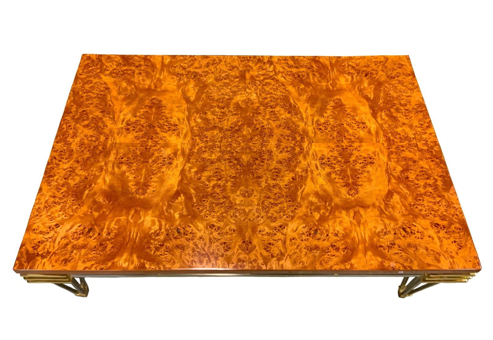 Stunning mid-century coffee table by Paul M. Jones showcasing captivating eye burl wood top in beautiful vibrant tones, exuding warmth to the piece. The table's brushed stainless steel frame not only ensures durability but also adds a sleek and