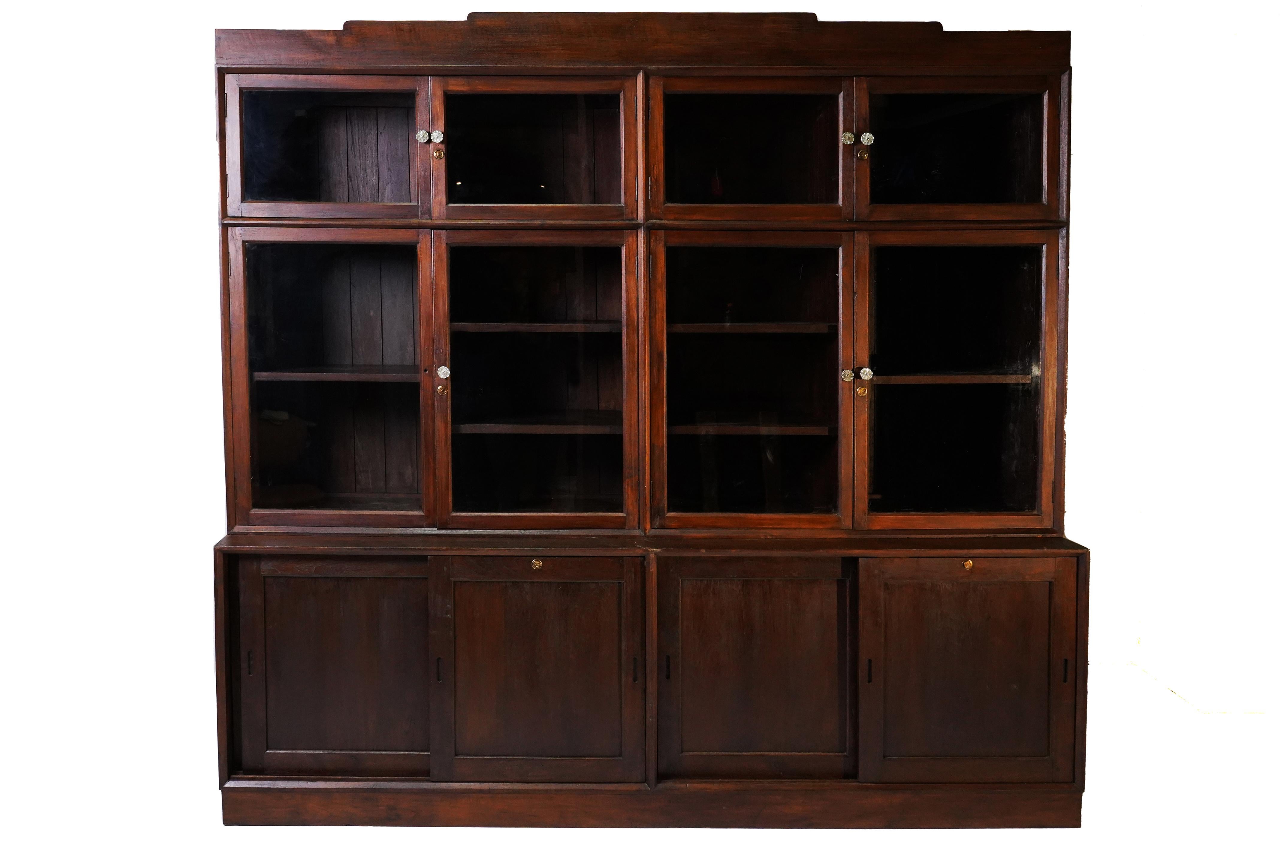 This solid teak bookcase was made in a sleek, modern style in Rangoon, Burma, near the very end of the British Empire. We call these pieces by different names; 
