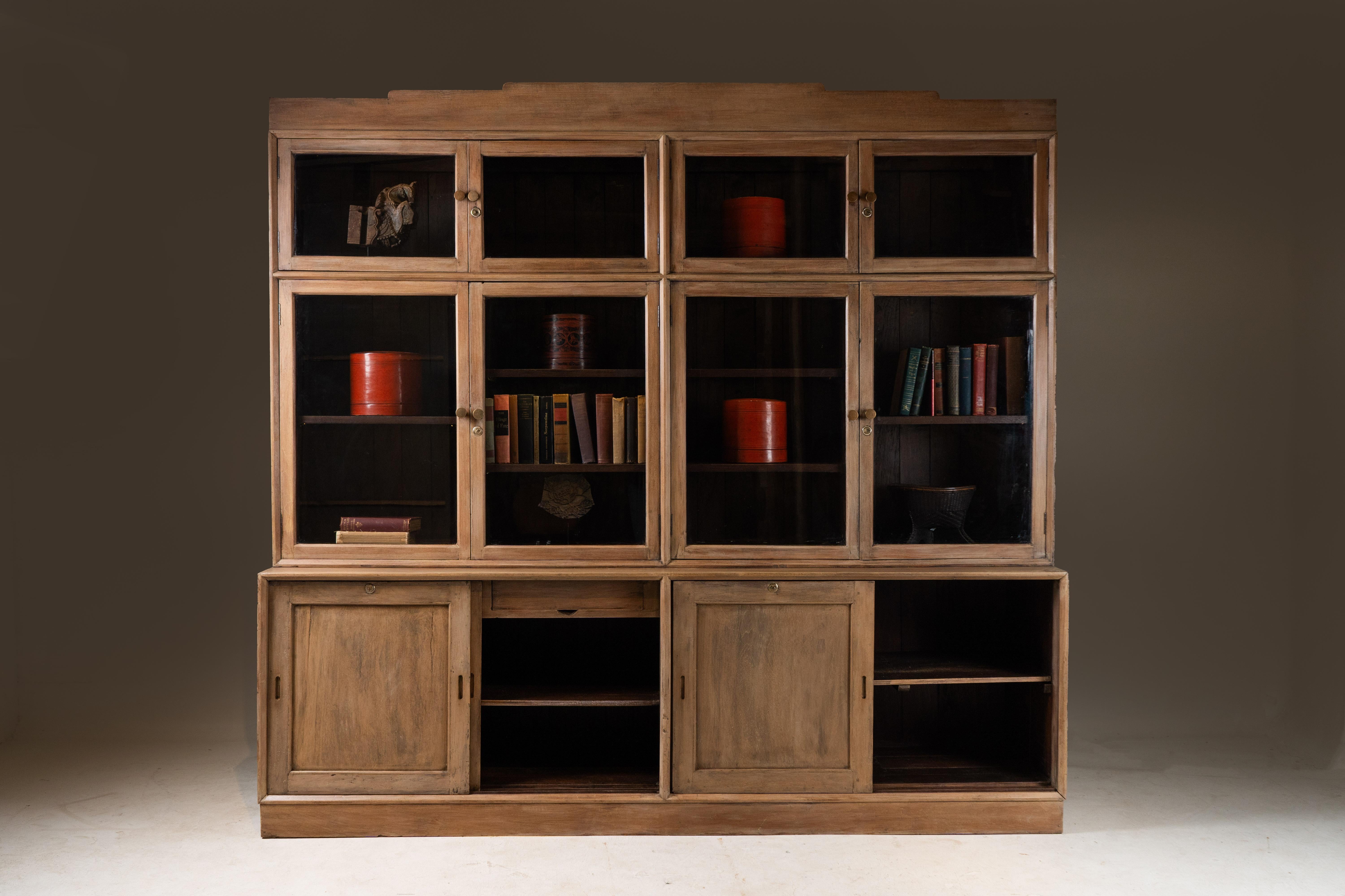 This solid teak bookcase was made in a sleek, modern style in Rangoon, Burma, near the very end of the British Empire. We call these pieces by different names; 