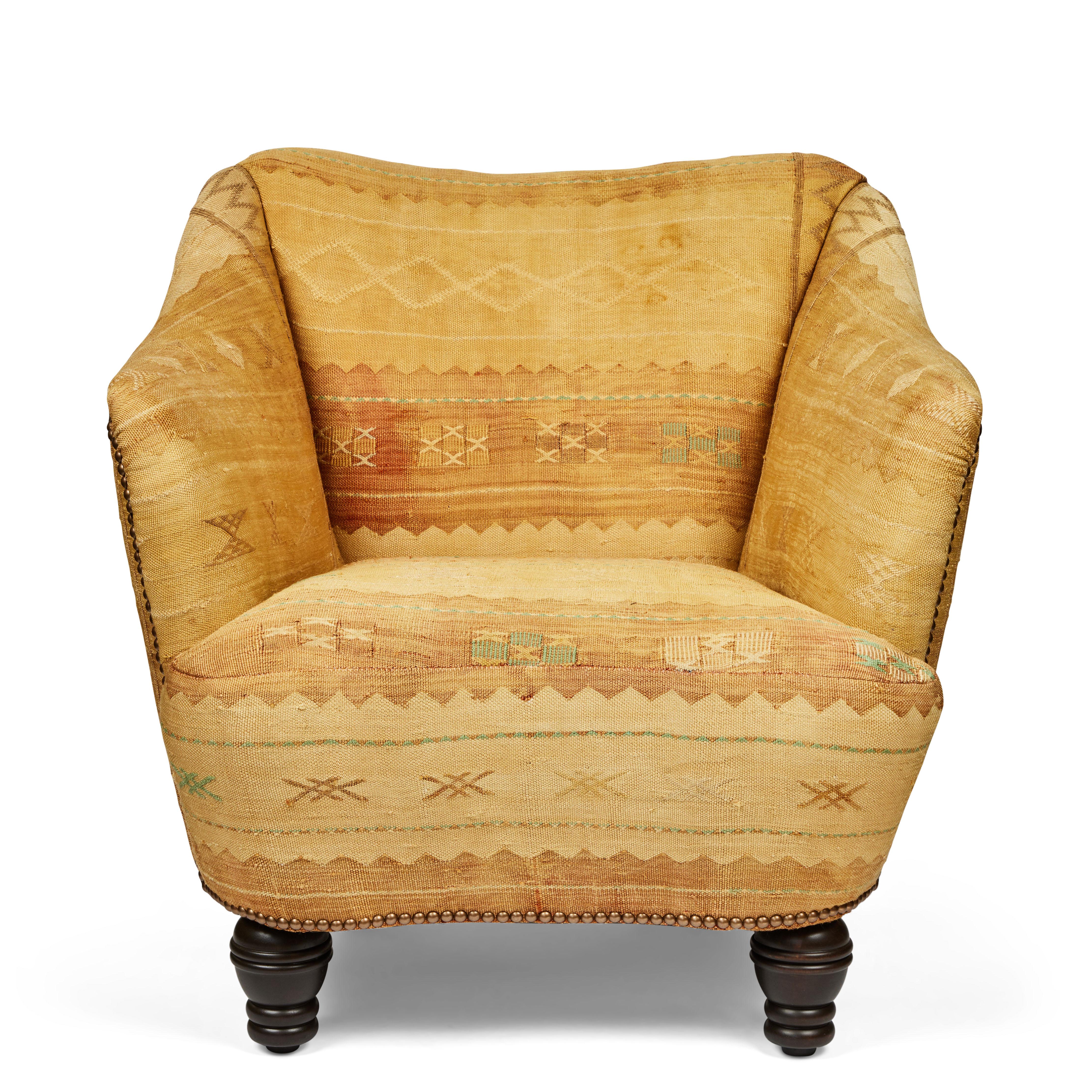 This sculptural winged chair is upholstered in a vintage serene color combination cactus cloth tapestry from Morocco which is so inviting. It has been outfitted with new turned chubby wood legs and accented with decorative brass nailhead detailing.