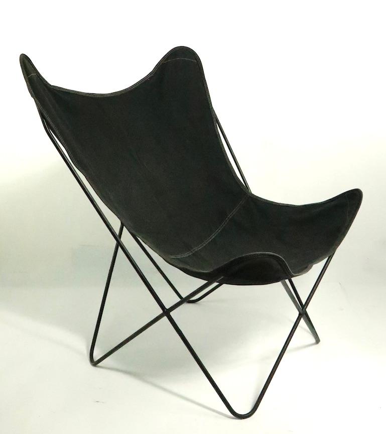 Period midcentury butterfly chair, having a wrought iron frame and original black canvas sling seat. This example is in very good, original clean ad ready to use condition. Iconic form, vintage design, still relevant today.