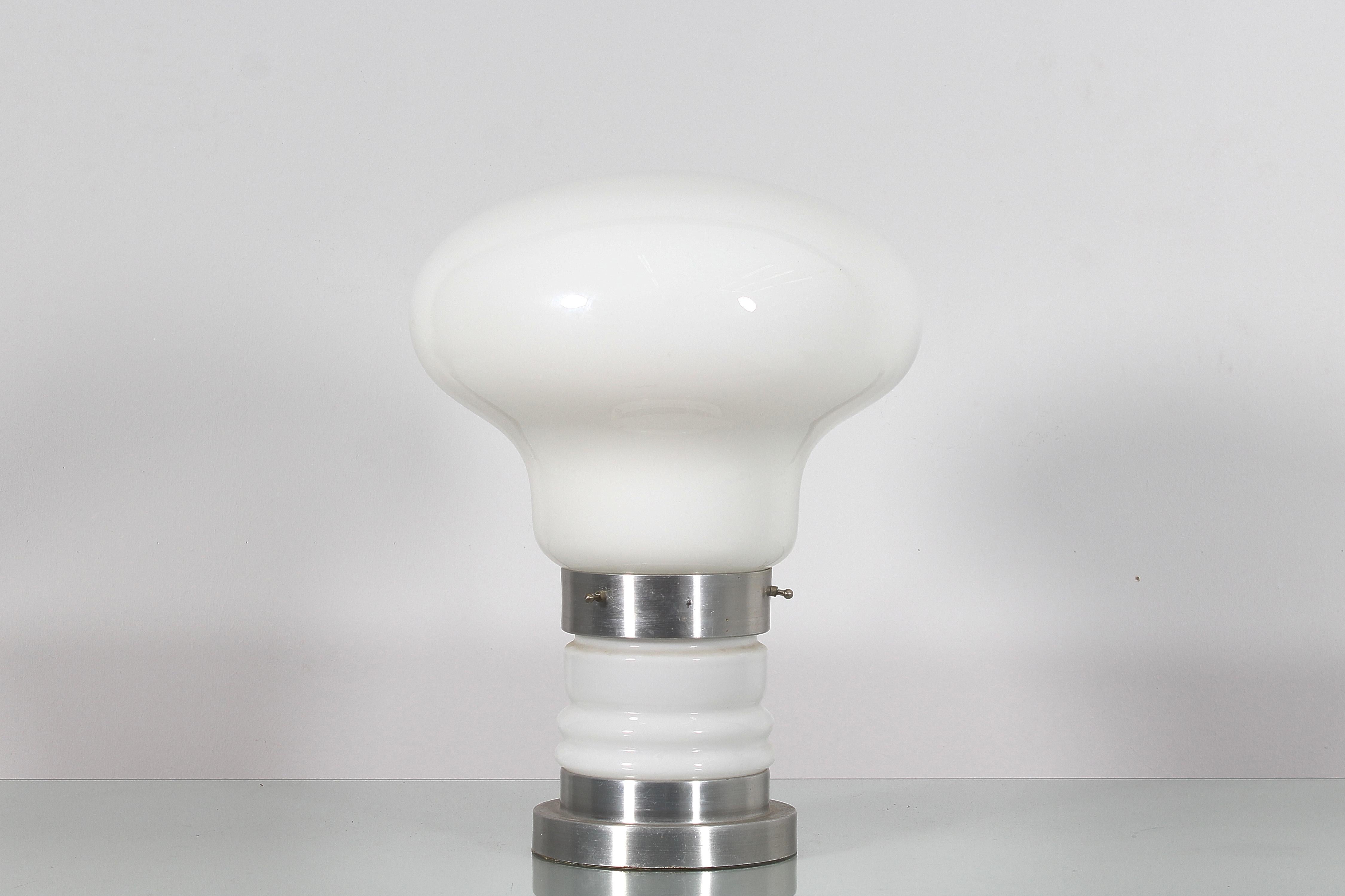 Bel exemple de lampe de table au design des années 70, en verre blanc de Murano, avec une base et un globe qui donnent à la lampe la forme d'une ampoule. Attribué à Carlo Nason pour Mazzega, années 1970.