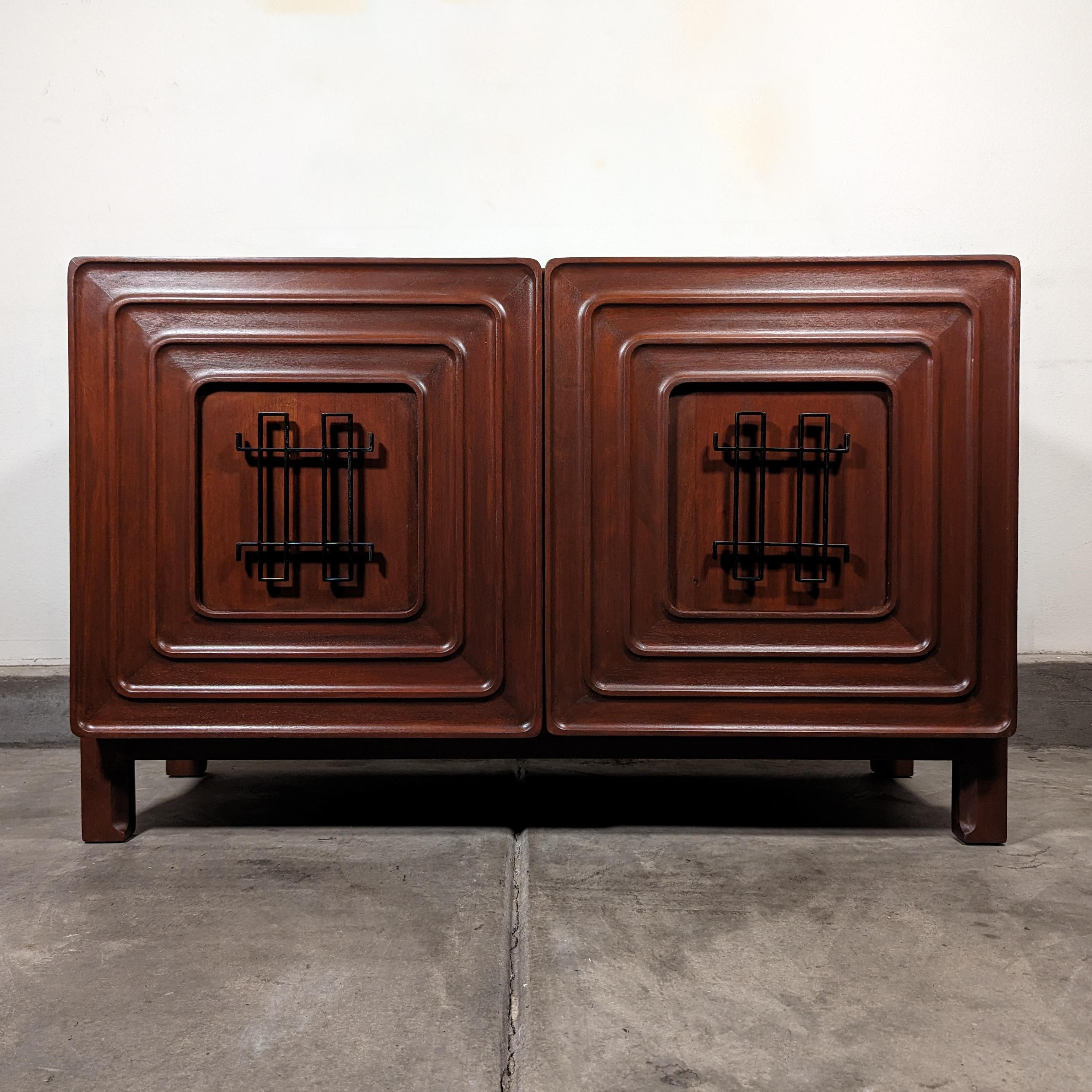 Immerse yourself in the rich history and craftsmanship of the mid-century era with this stunning cabinet, designed by the iconic Edmond J. Spence and manufactured by Industria Mueblera of Mexico in the 1950s. This versatile piece can seamlessly