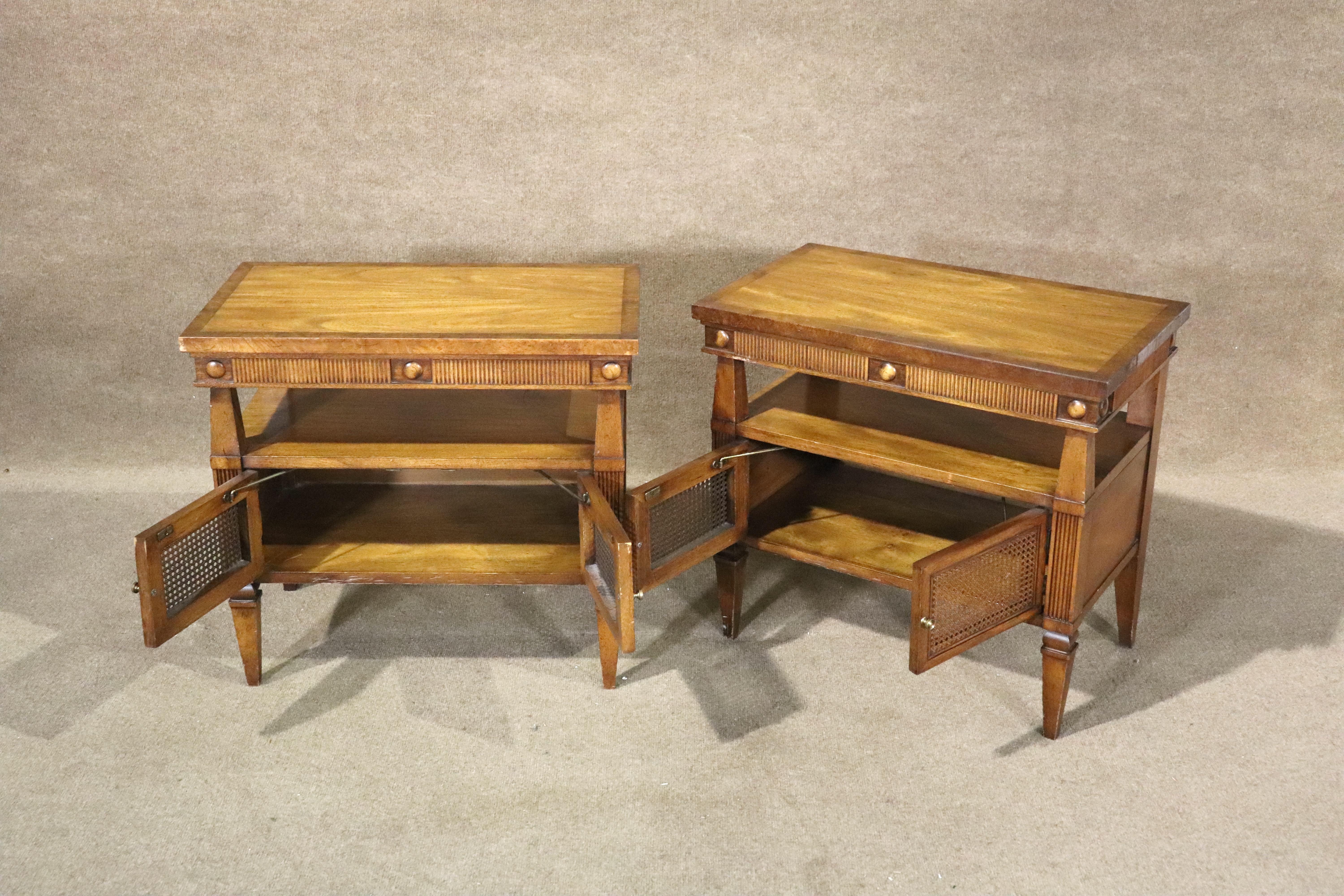 Paire de tables d'appoint vintage avec rangement. Grain de noyer chaud avec une garniture en bois bruni. Rangement à deux portes avec cannage.
Veuillez confirmer le lieu NY ou NJ