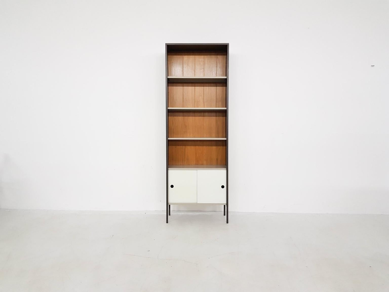 Elegant bookcase with a cabinet at the bottom by Dutch mid-century designer Coen de Vries. Made by Pilastro the Netherlands in the 1960s.

Metal industrial bookcases and shelving systems are among the most known items from the Dutch midcentury.