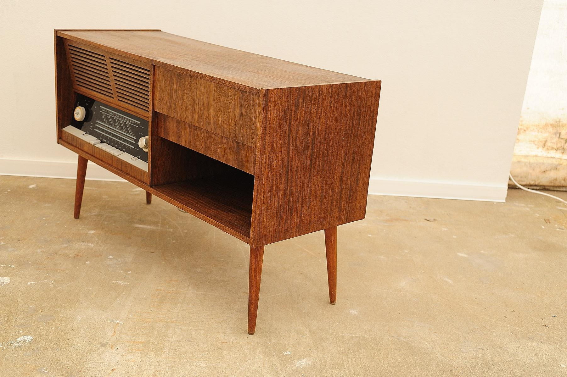 Mid century cabinet with build-in turntable and radio, it was made in the former Czechoslovakia in the 1950´s. The construction is made of wood in a walnut veneer. The Gramophone and radio are functional.
Inside the cabinet are also storage
