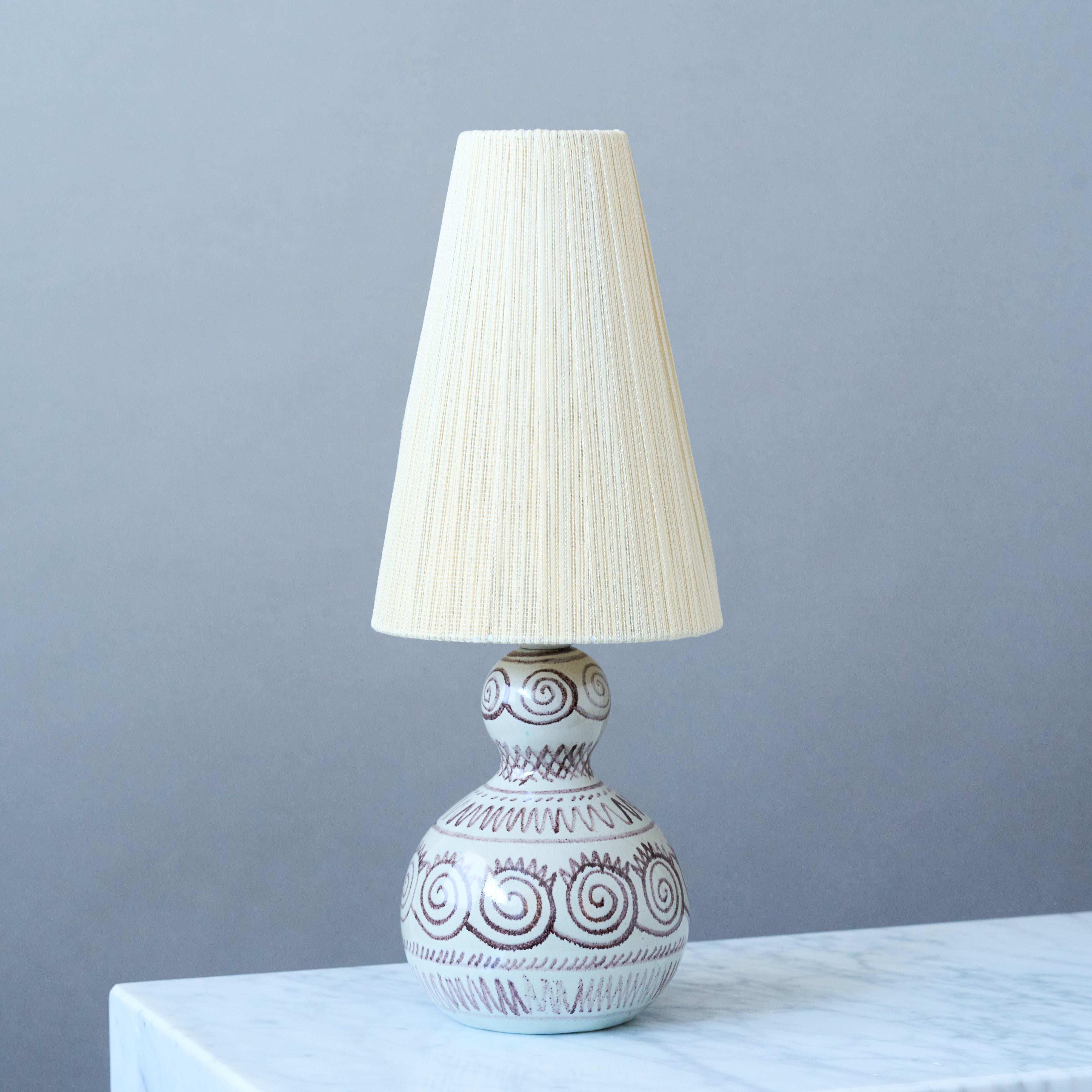 A beautiful mid-century calabash-shaped earthenware table lamp with amazing hand-painted pattern.
Made by Elsi Bourelius in her studio in Löberöd, Sweden, 1950s.

Good original condition. Two tiny chips underneath the lamp (pictured).
Signed