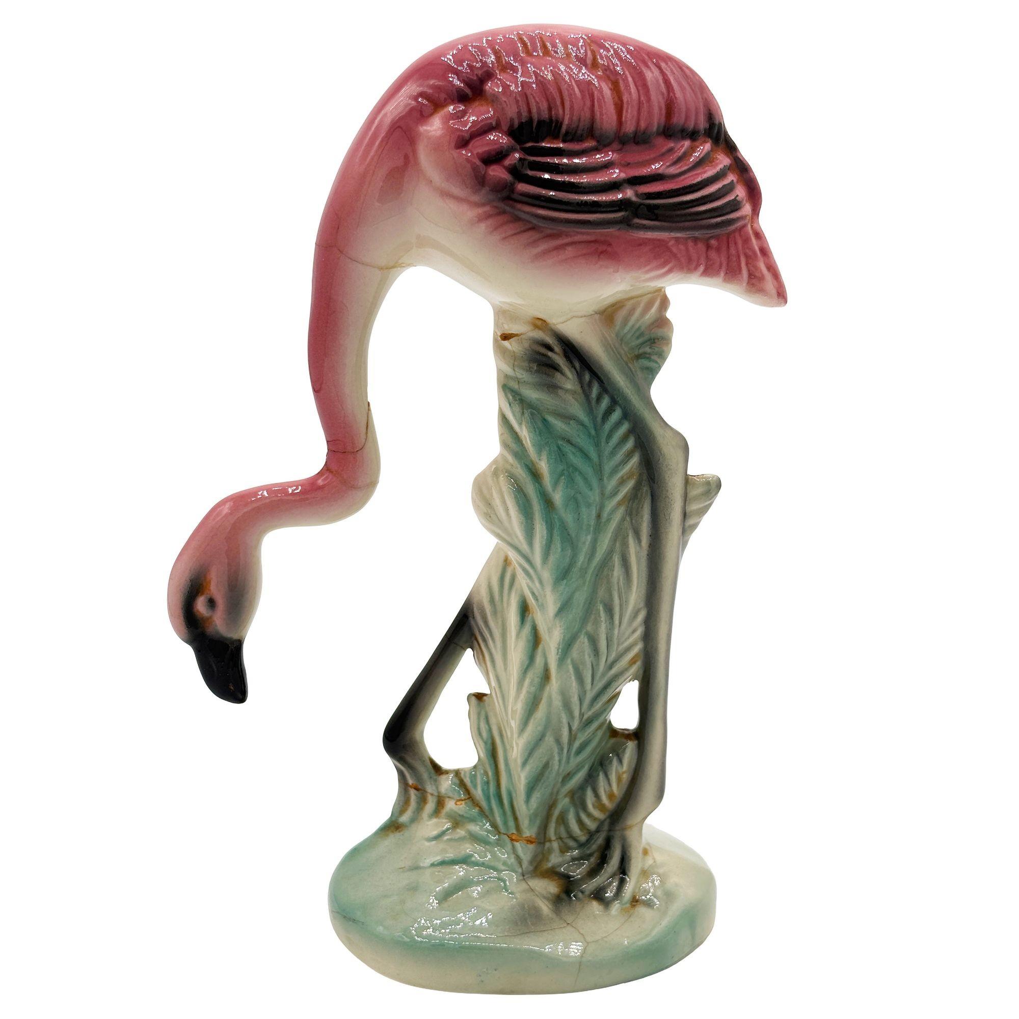 Statuetta in ceramica del fenicottero di Greene & Greene, rosa e verde, risalente alla metà del secolo scorso. La statua raffigurava un fenicottero rosa dalle lunghe zampe, una forma snella e alta in piedi su un campo erboso, che si inchinava per