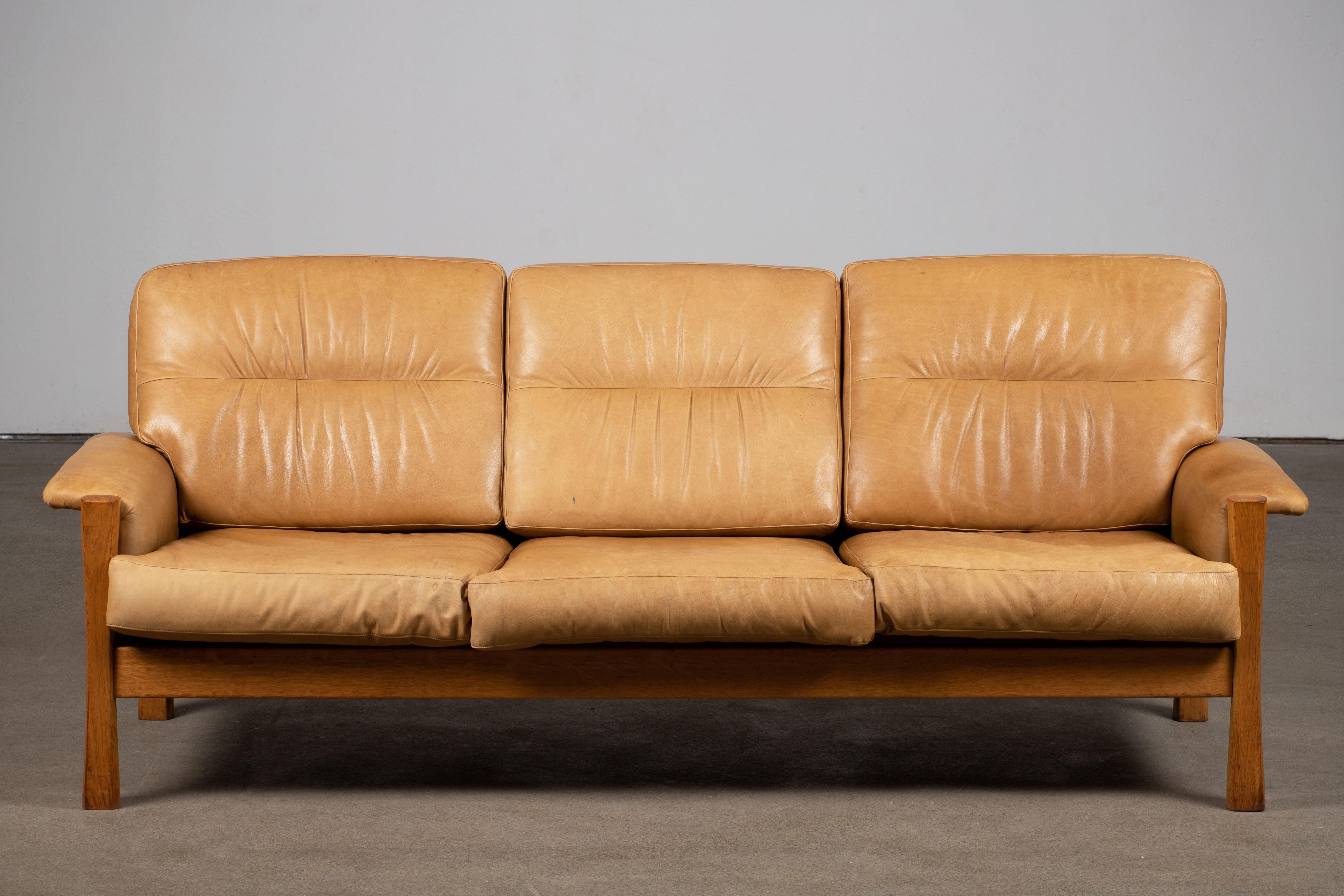 Inspired by Pierre Chapo, Mid-Century three seater sofa in Camel leather featuring a superb patina, oak wood structure. Elegant design and great comfort.

We also have the matching two seater sofa and armchair on our storefront.