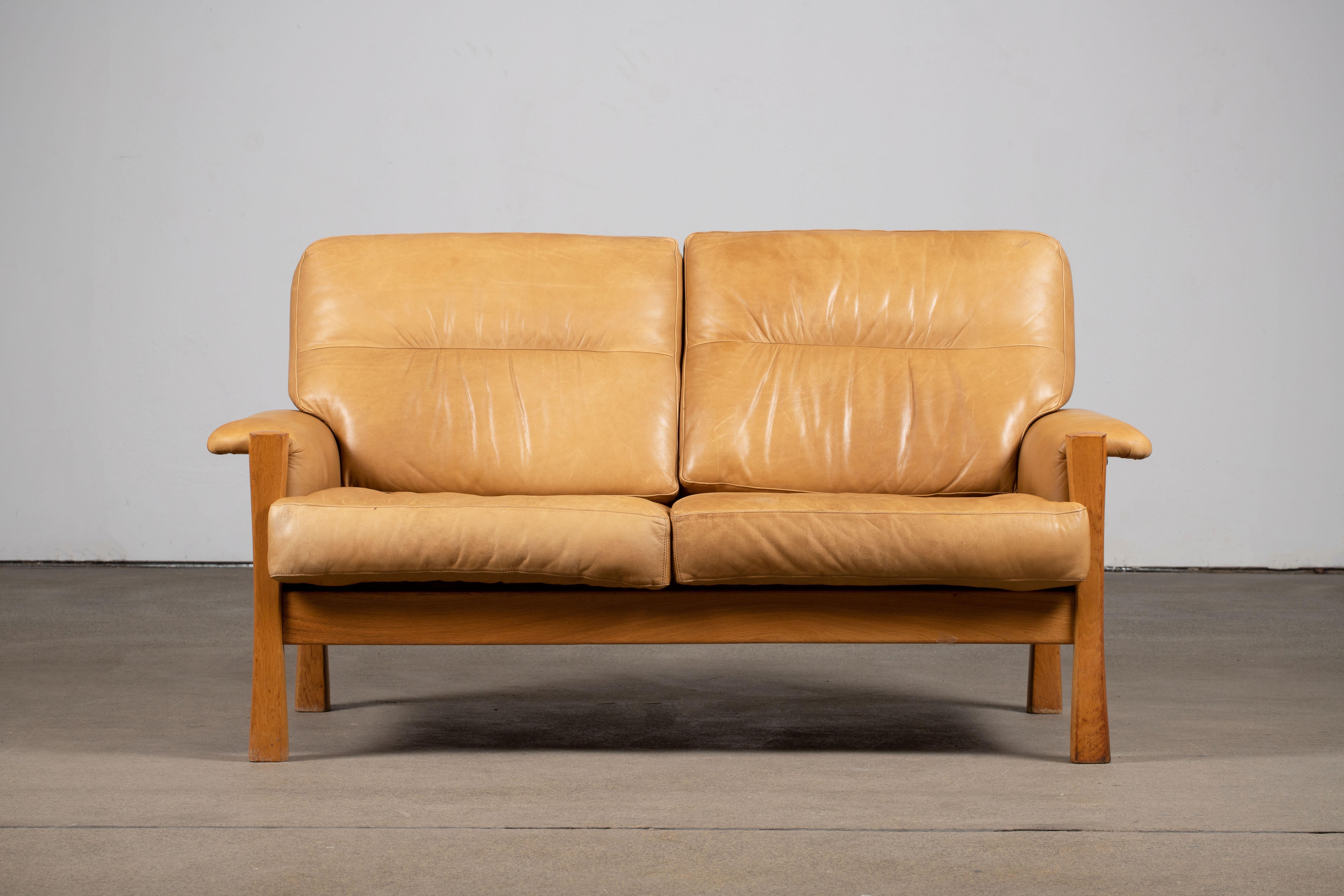 Inspired by Pierre Chapo, mid-century two seater sofa in Camel leather featuring a superb patina, oak wood structure. Elegant design and great comfort.

 