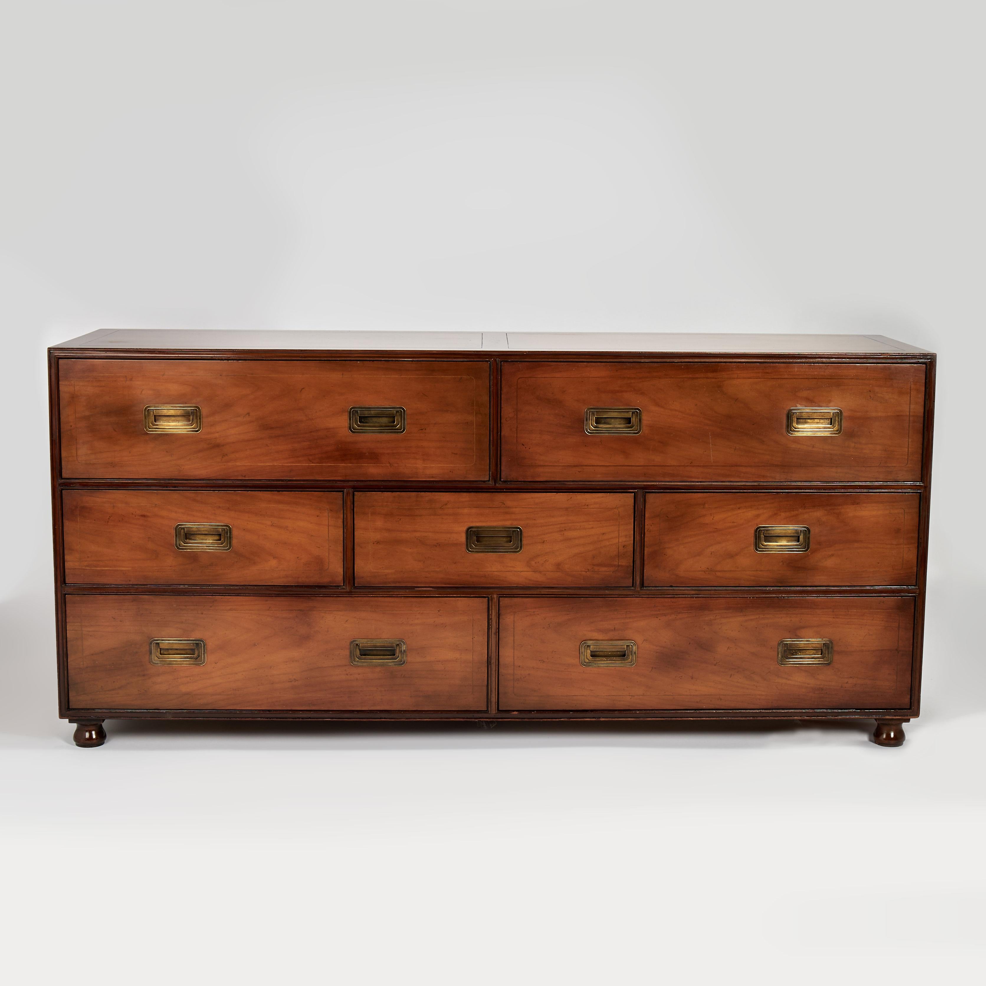 Preciosa cómoda vintage de estilo British Colonial fabricada en nogal con siete cajones, herrajes de campaña de latón y patas torneadas clásicas. Combinación perfecta de lo tradicional y lo moderno. Firmado Baker en un cajón. 