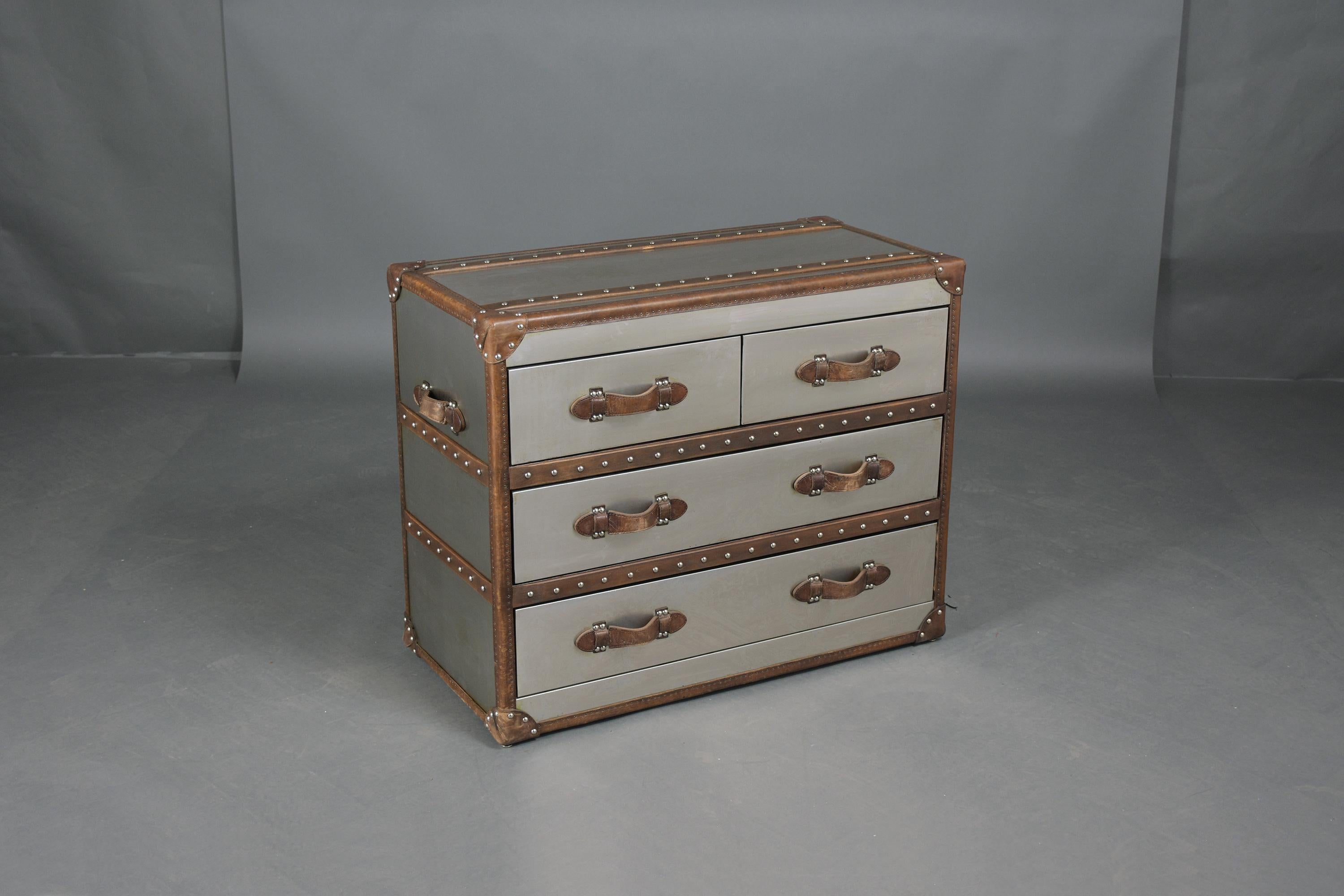 This extraordinary 1990s Mid-Century Modern Campaign-style chest of drawers has been professionally restored by our team of expert craftsmen and is crafted out of wood with metal & leather details. The dresser comes with four drawers, two small top