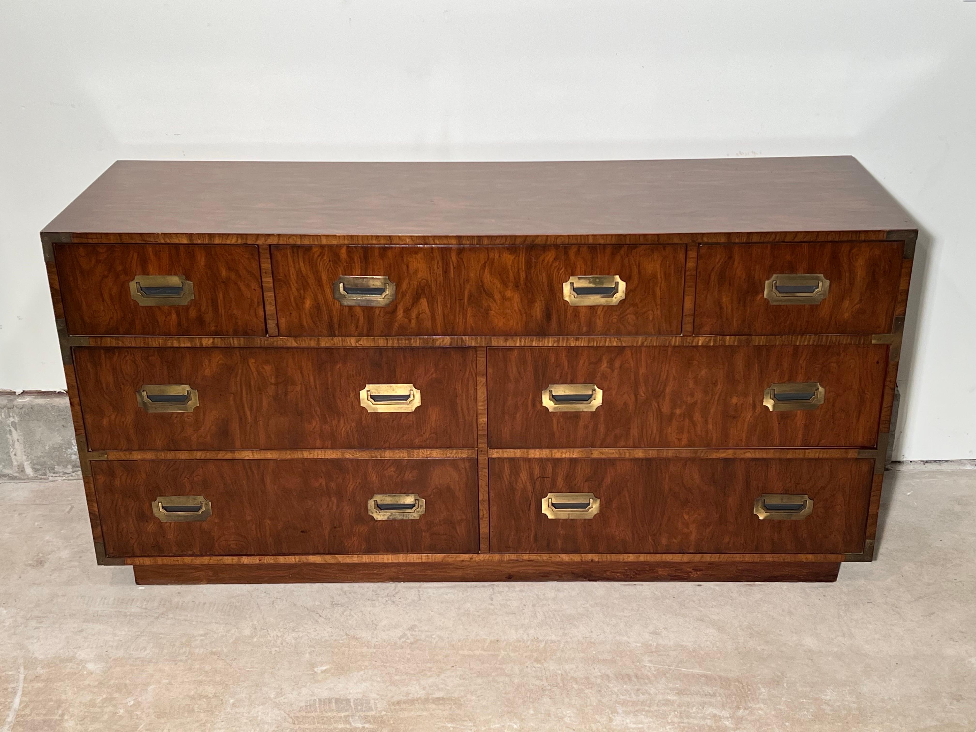 Mid Century Campaign dresser in the style of Henredon. The Campaign series by Dixie Furniture company out of South Carolina. Classic 7 drawer dresser in a gorgeous Walnut finish. This set has a recessed plinth base and has large recessed antique