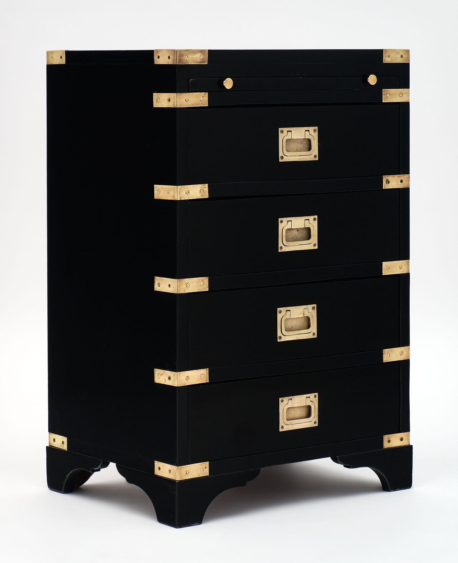 English Campaign midcentury side table with a pullout / pull-out tablet and finished with a lustrous French polish. This ebonized piece has gilt brass hardware throughout and a strong presence in any space.