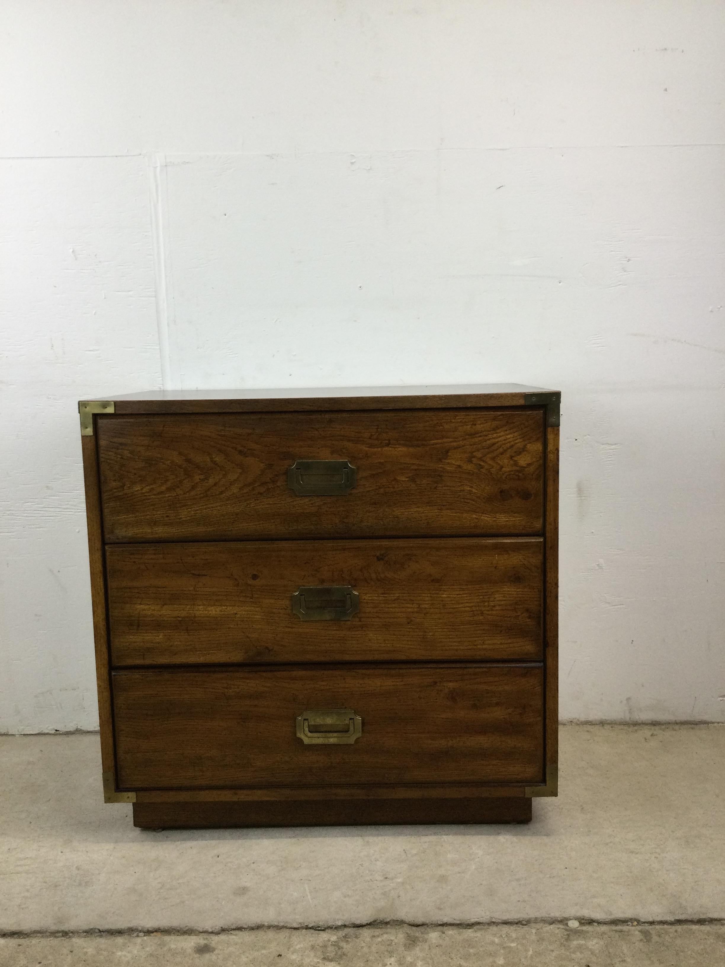 This mid century campaign style dresser features dark oak finish, durable vinyl top with faux wood grain, three dovetailed drawers, and brass accented hardware.

Matching three drawer chest & highboy dresser available separately.

Dimensions: 30w