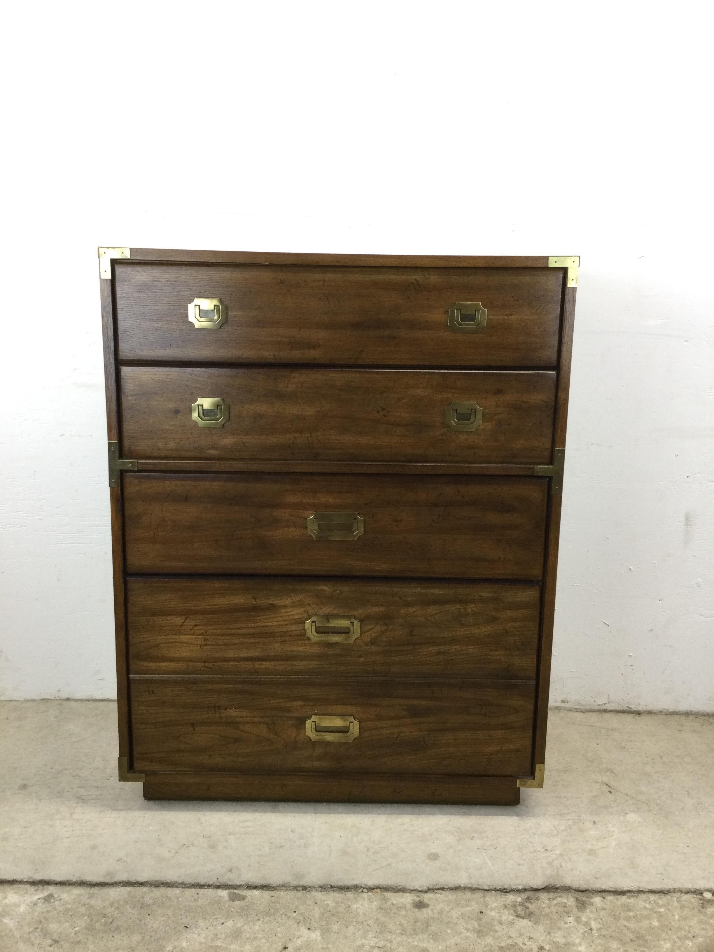 This mid century highboy dresser features dark oak finish, durable vinyl top with faux wood grain, five dovetailed drawers, and brass accented hardware.

Pair of matching three drawer chests available separately.

Dimensions: 34w 18d