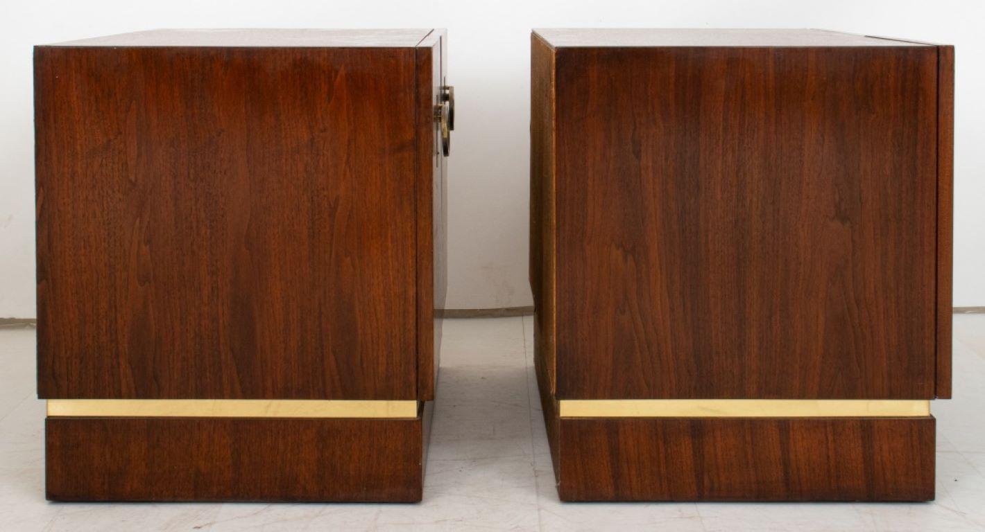 Mid-Century Modern Walnut End Cabinets, a pair, each rectangular above two cabinet doors with ring pulls above a brass-inlaid plinth, opening to reveal shelves. 

Dealer: S138XX