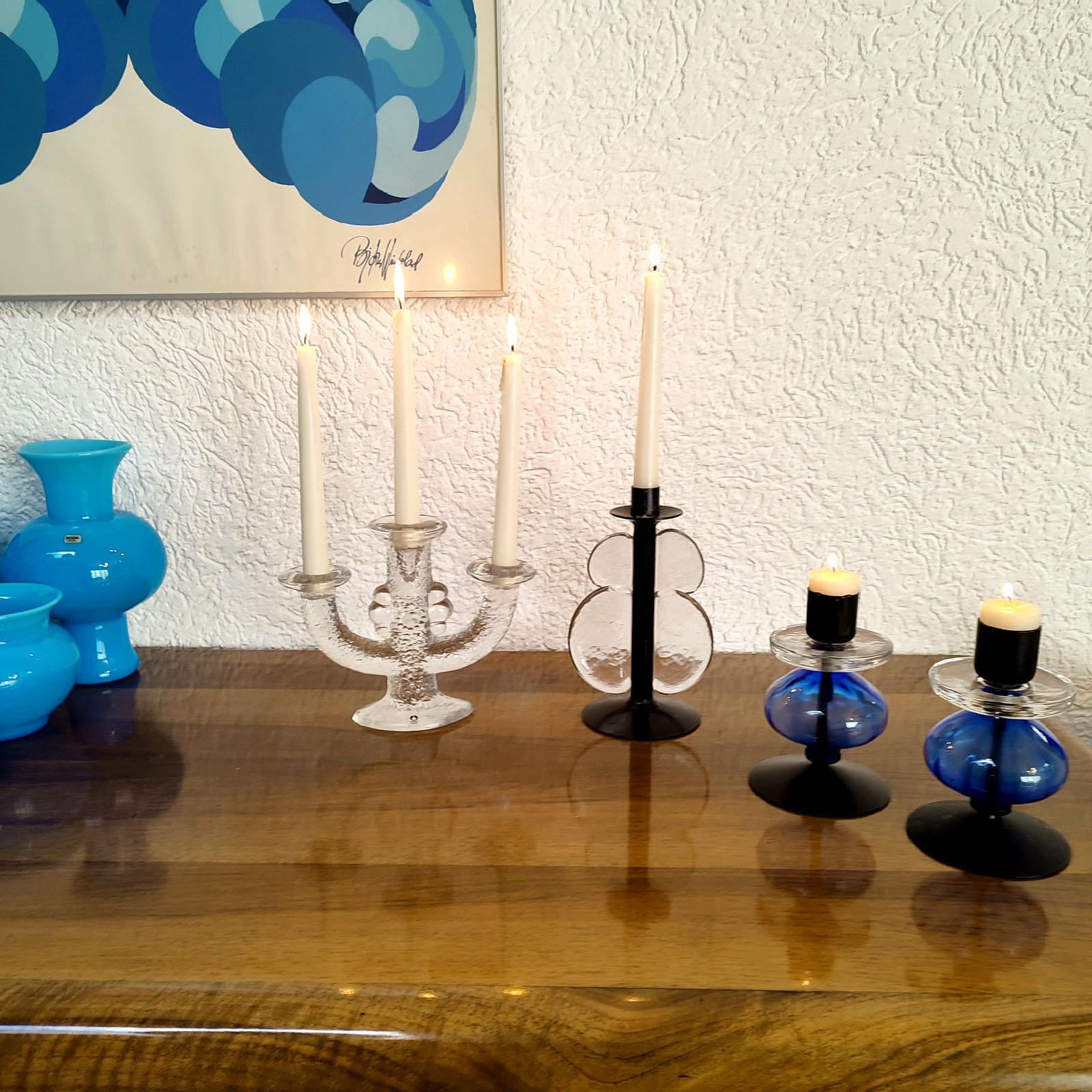 A unique candle holder made of black painted iron and transparent glass, in the well known style of Erik Höglund. The glass element decorate artistically de black painted iron stem, creating the stylized image of a butterfly. For 2 cm candles. In a