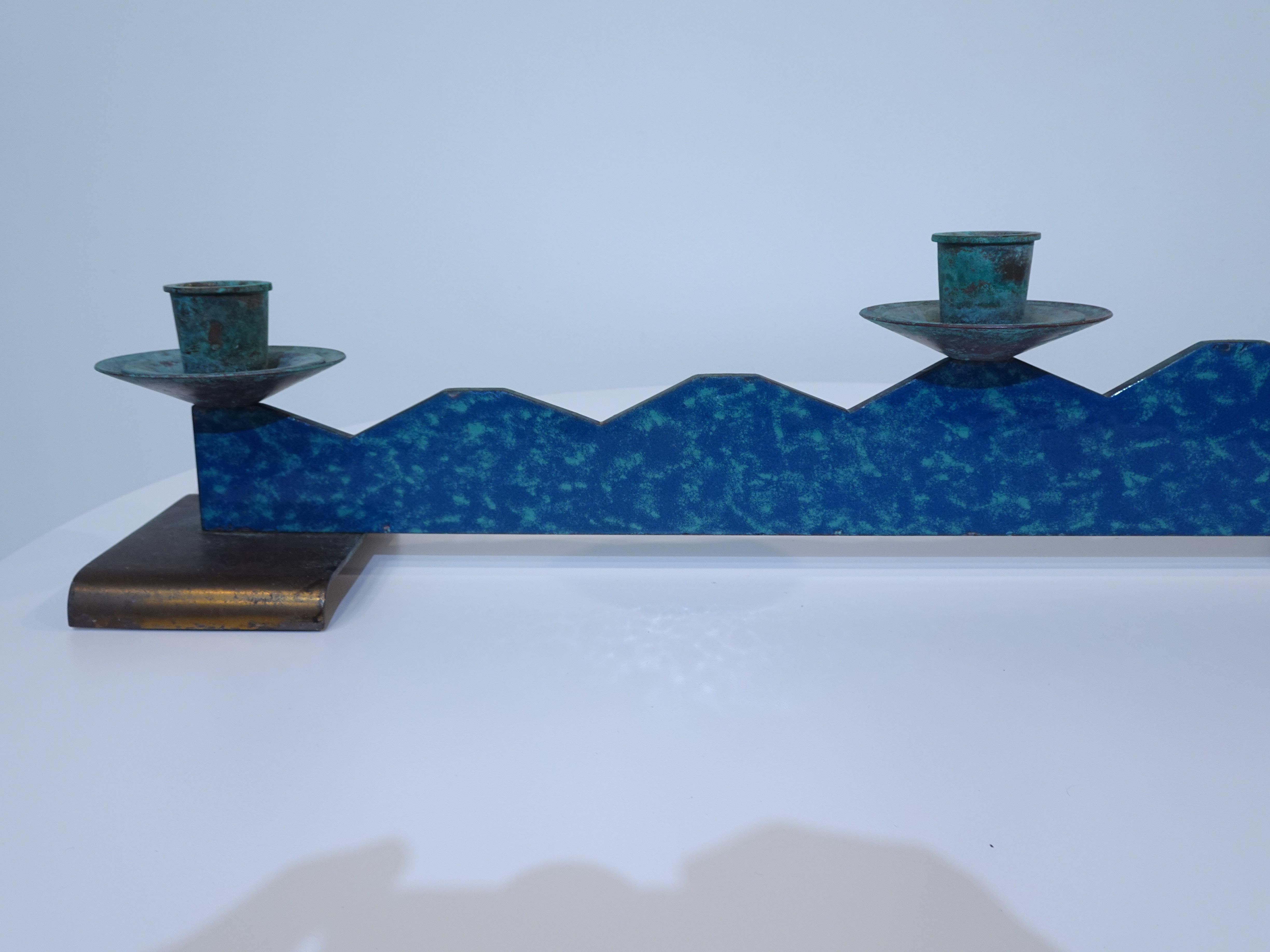 A well crafted candlestick center piece in a mixed blue toned copper enameled metal with step down design and three copper candle holders. The holders have great age and patina which complements the piece and the large platforms or feet which are on