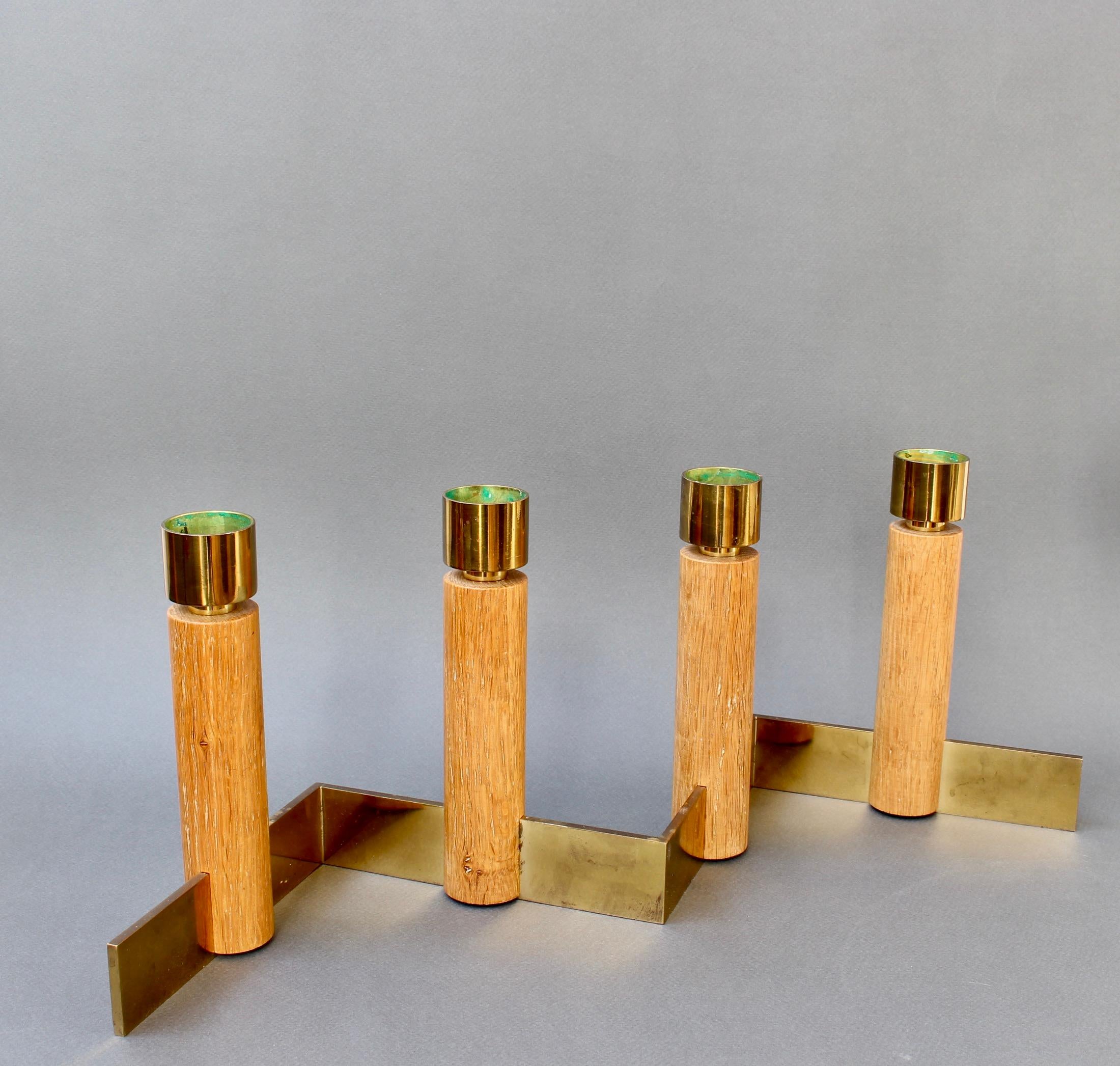 Mid-century candlestick holder by Hans Agne Jakobsson (circa 1950s). Brass base supports four wooden candlesticks topped by wide-candle brass receptacles. The well known designer was a master of light in all its forms. In fair overall condition with