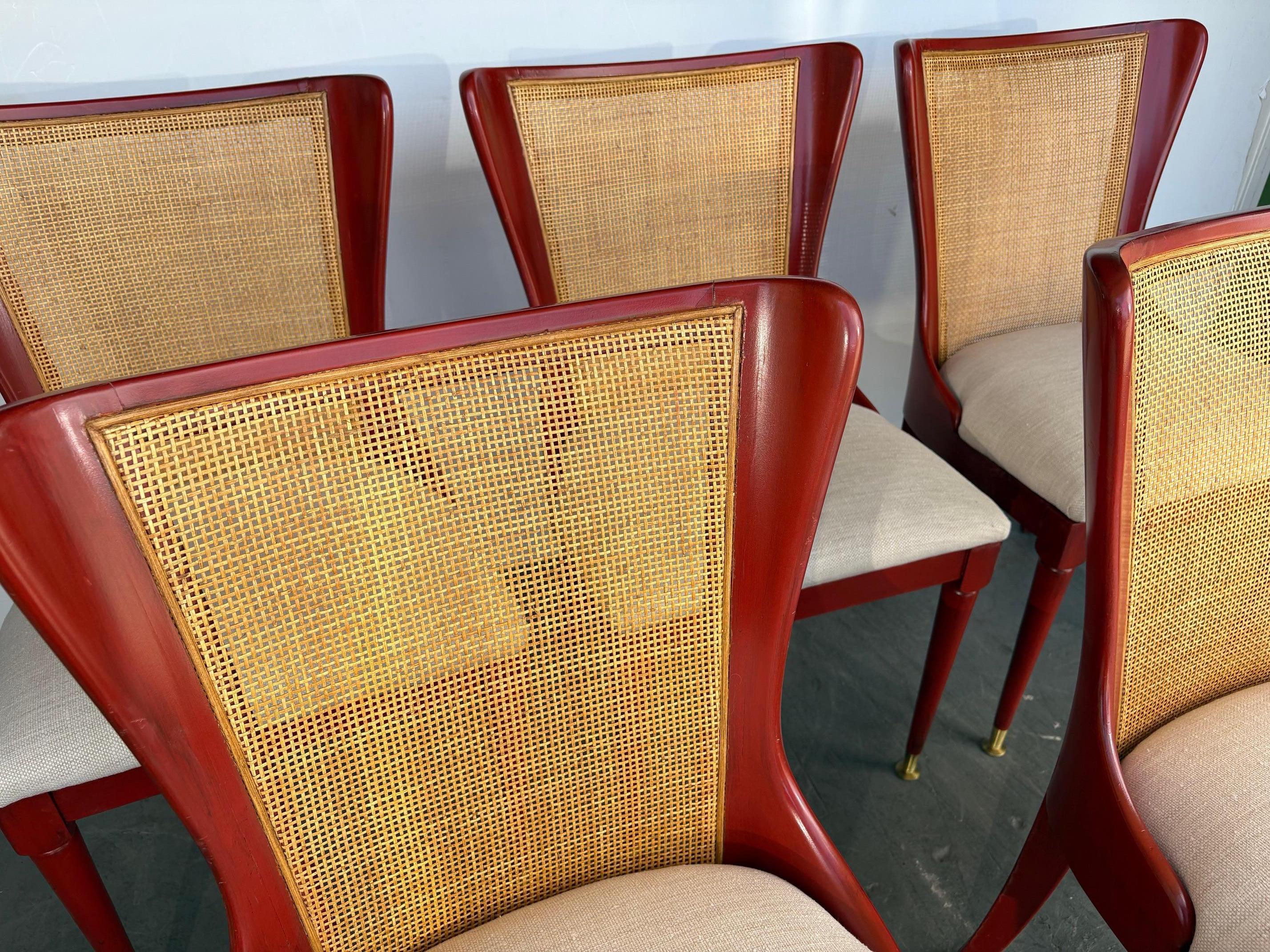 Un set di 6 sedie da pranzo. Le sedie sono rifinite in rosso e hanno lo schienale in canna con piedi in ottone. I sedili sono stati recuperati.