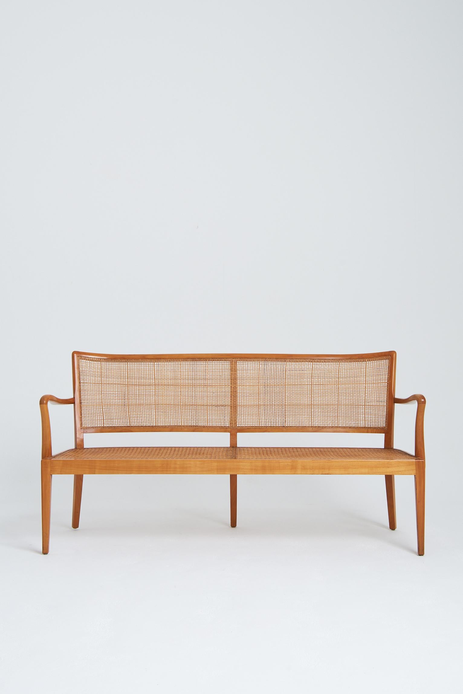 A cherry wood and cane settee by Rudolf Frank (1898–1974).
Germany, circa 1955.
  