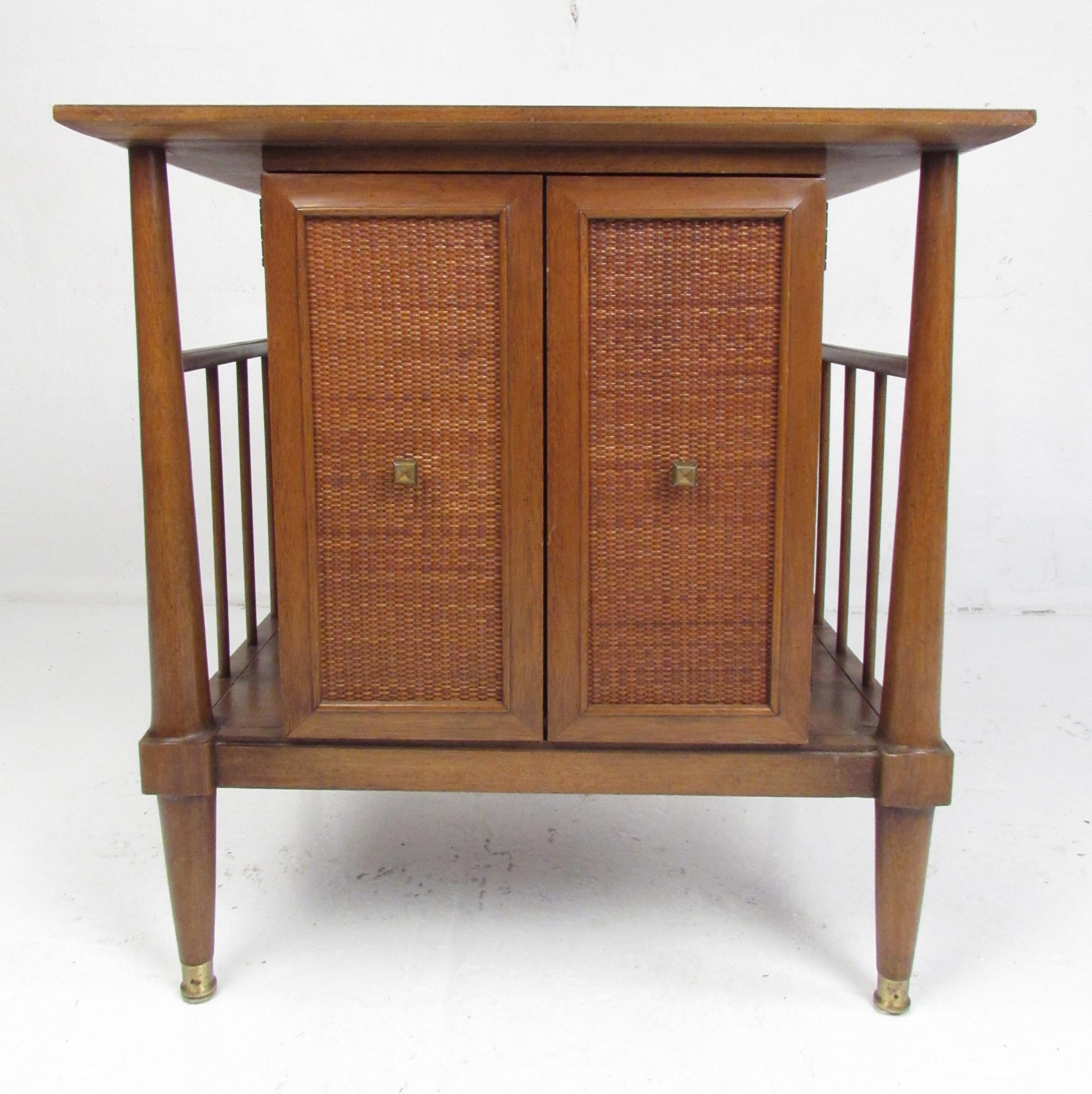 These end tables/nightstands feature beautiful walnut wood grain with attractive caned fronts with original brass pulls and capped feet. They provide ample storage, each with an open cabinet space behind two cane front doors and a single dovetailed